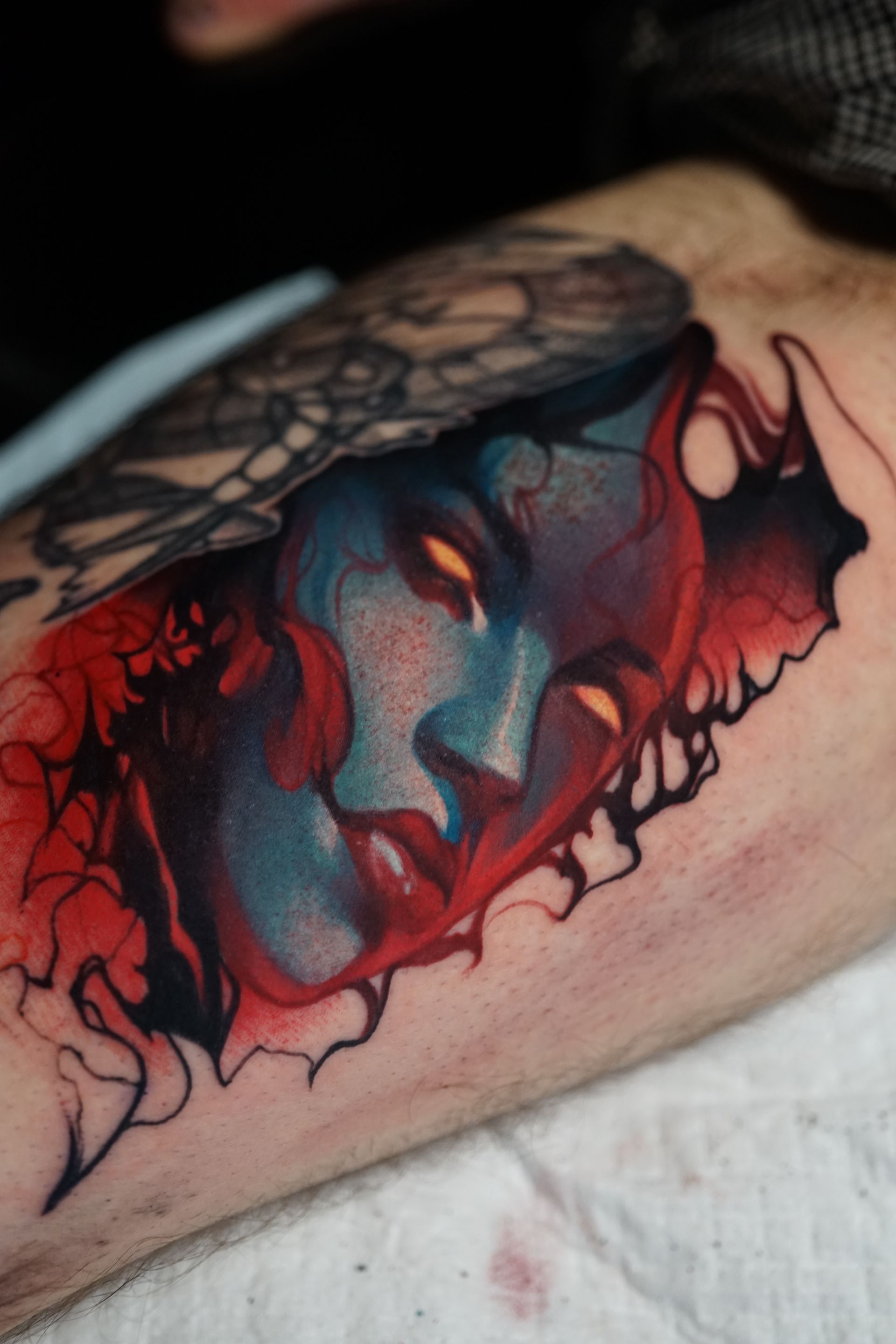 A person has a colorful tattoo of a woman 's face on their arm.