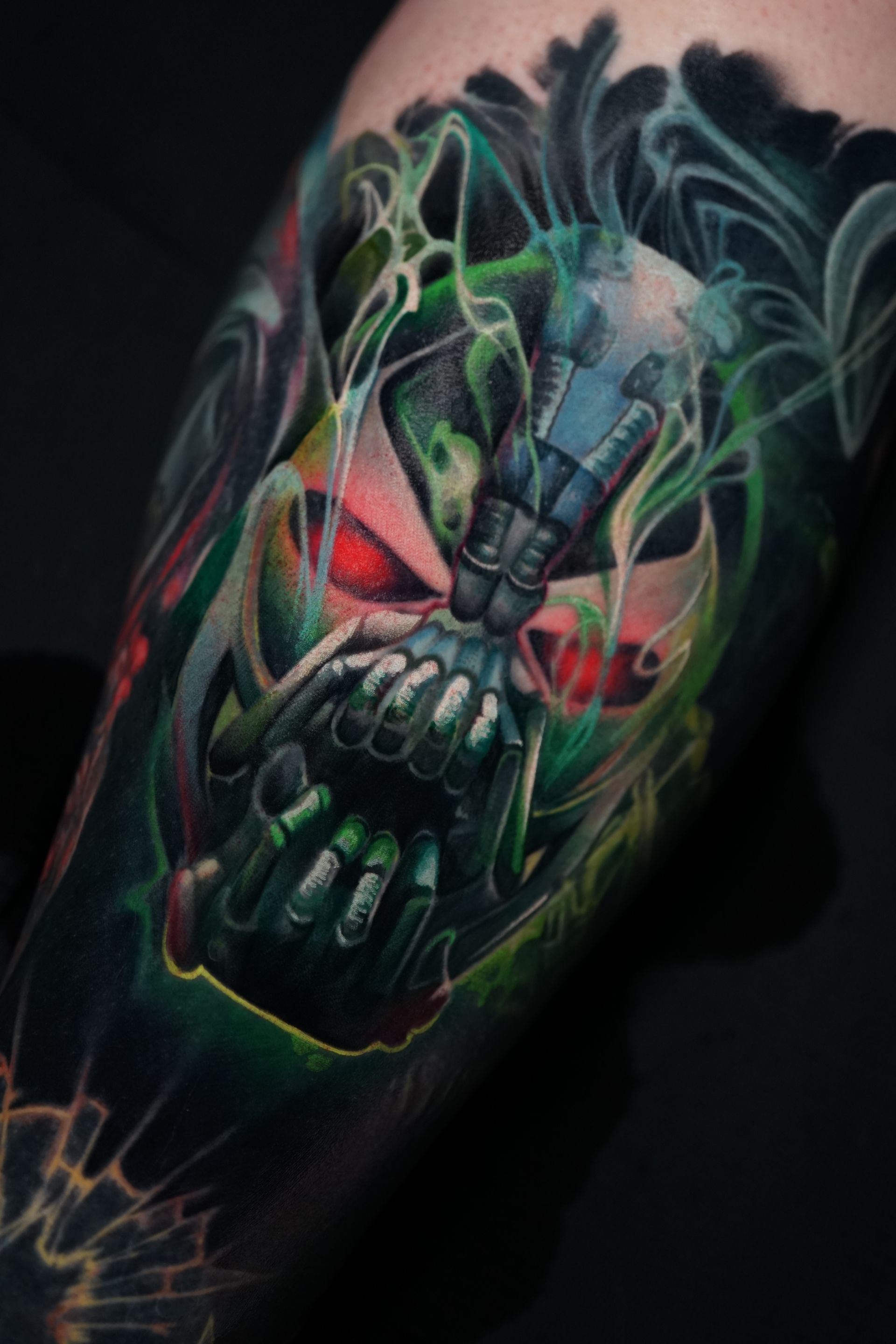 A close up of a tattoo of bane on a person 's arm.