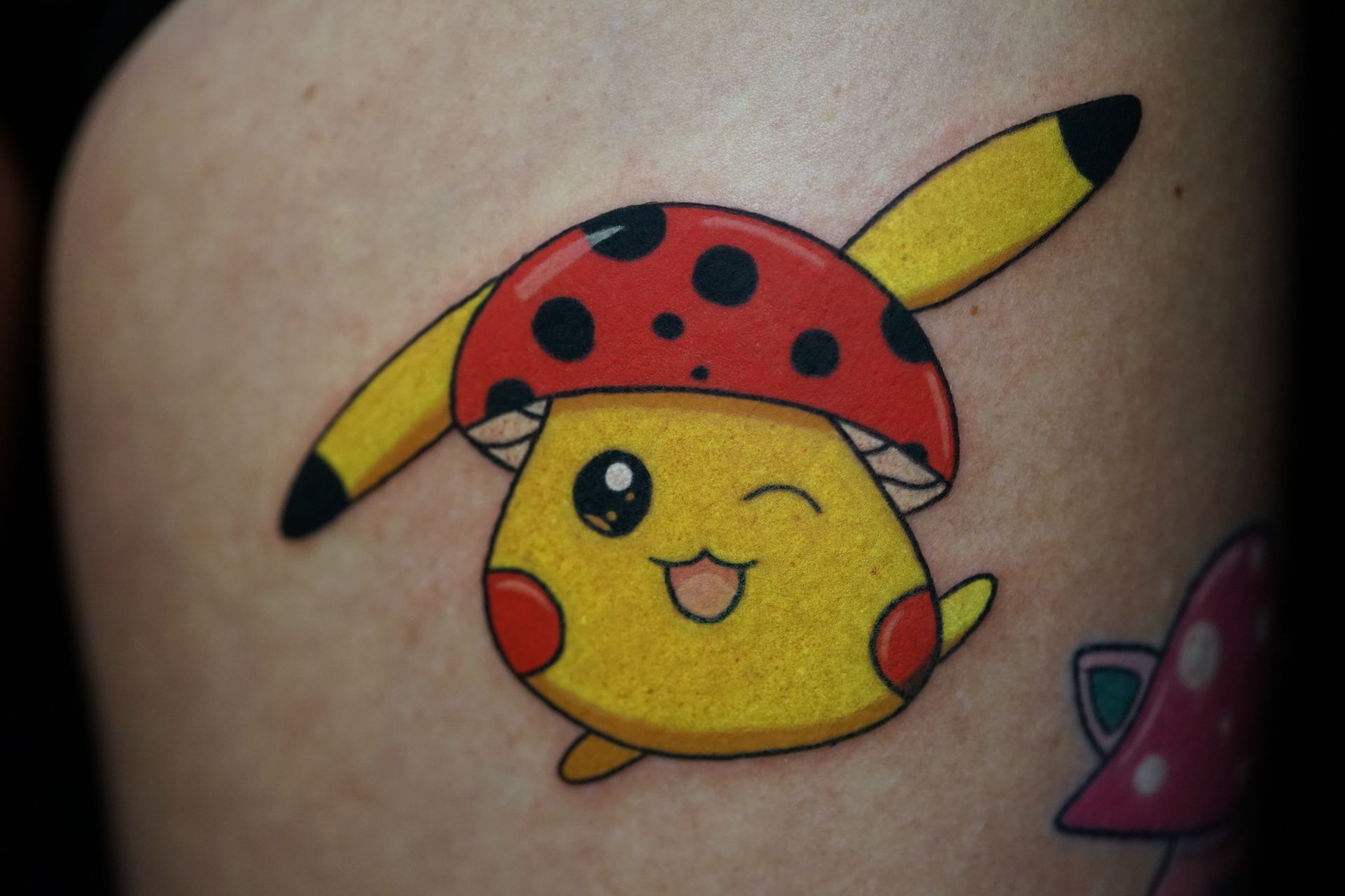 A tattoo of a pikachu wearing a ladybug hat