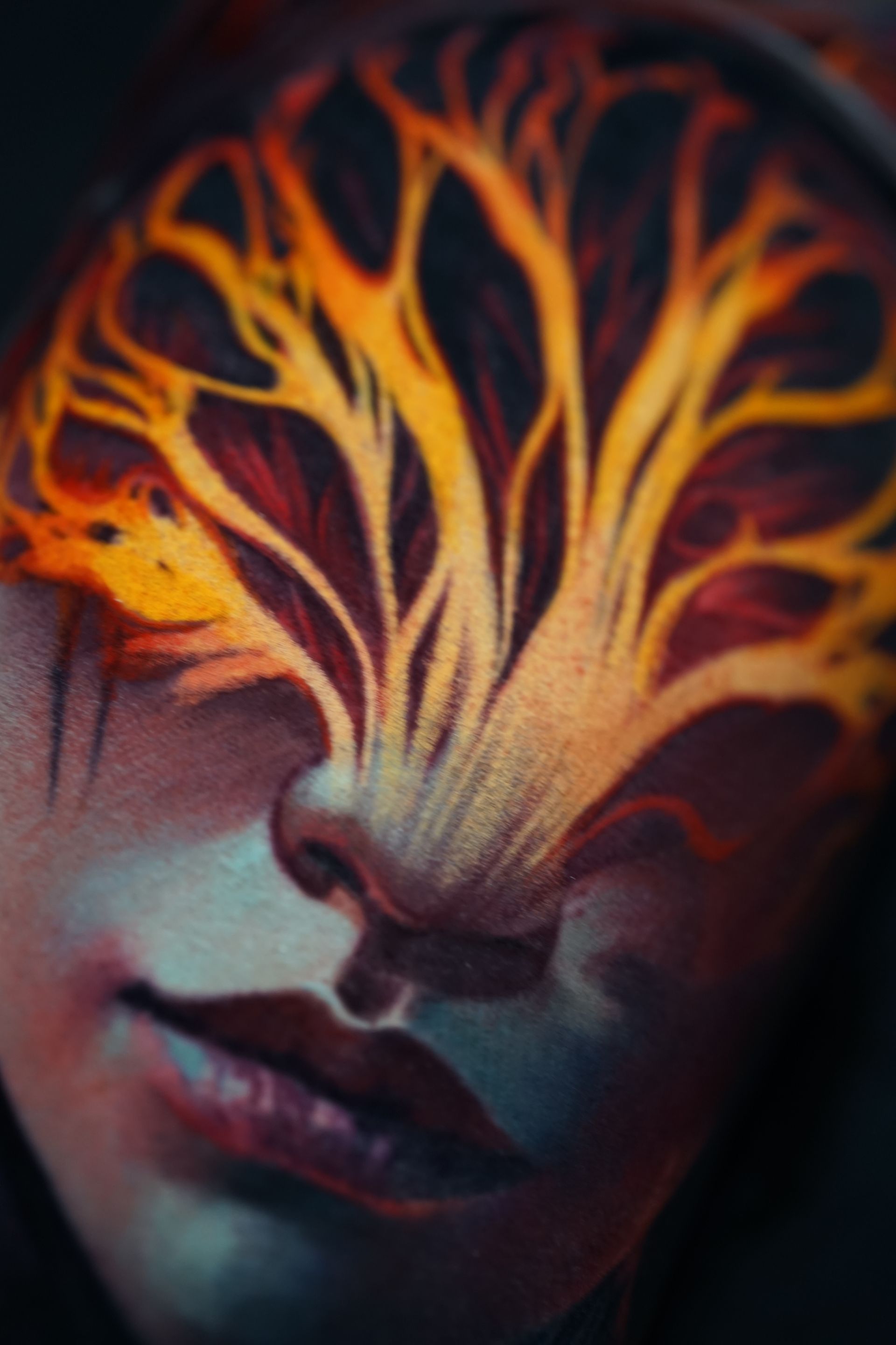 A close up of a woman 's face with a tree painted on it