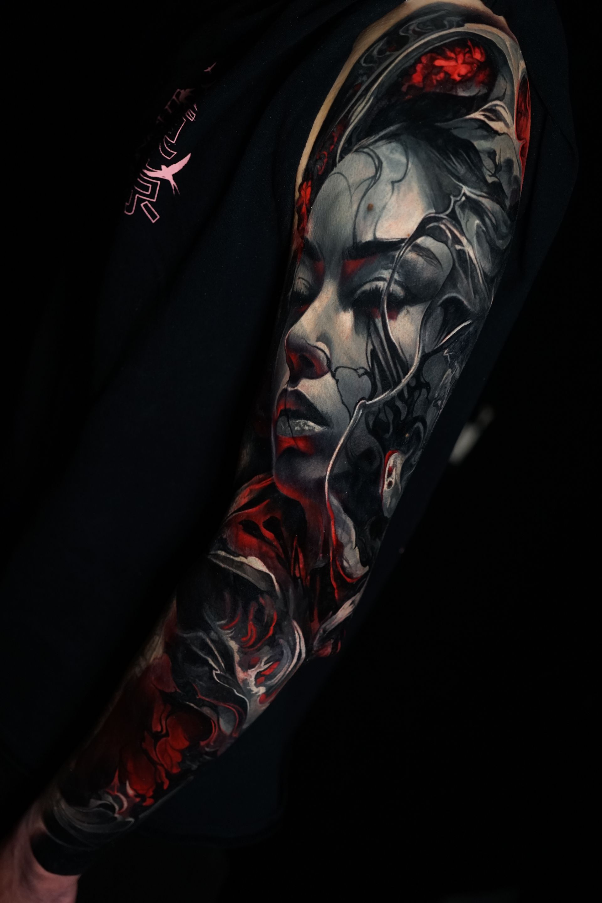 A person has a tattoo of a woman 's face on their arm.