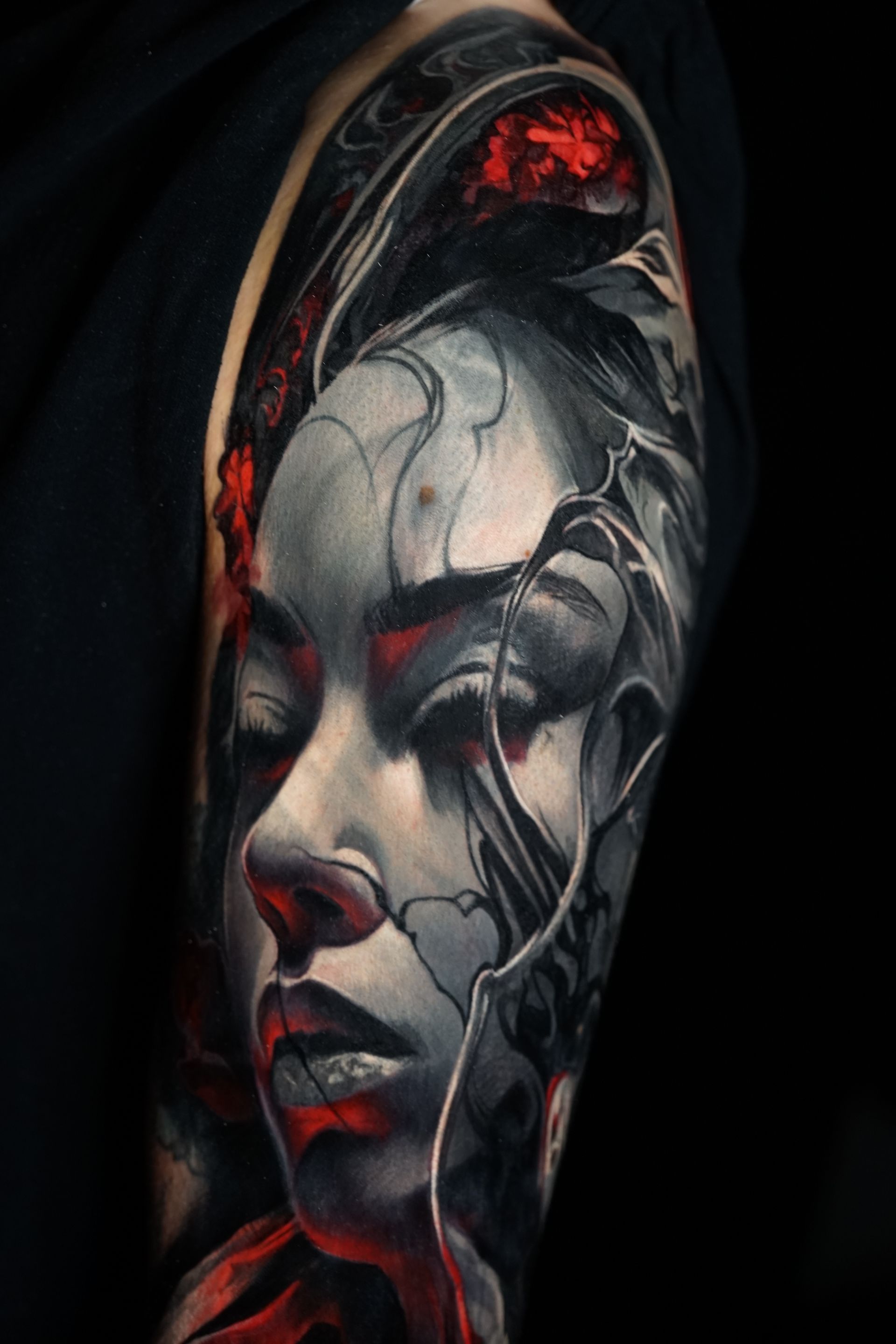 A close up of a tattoo of a woman 's face on a person 's arm.