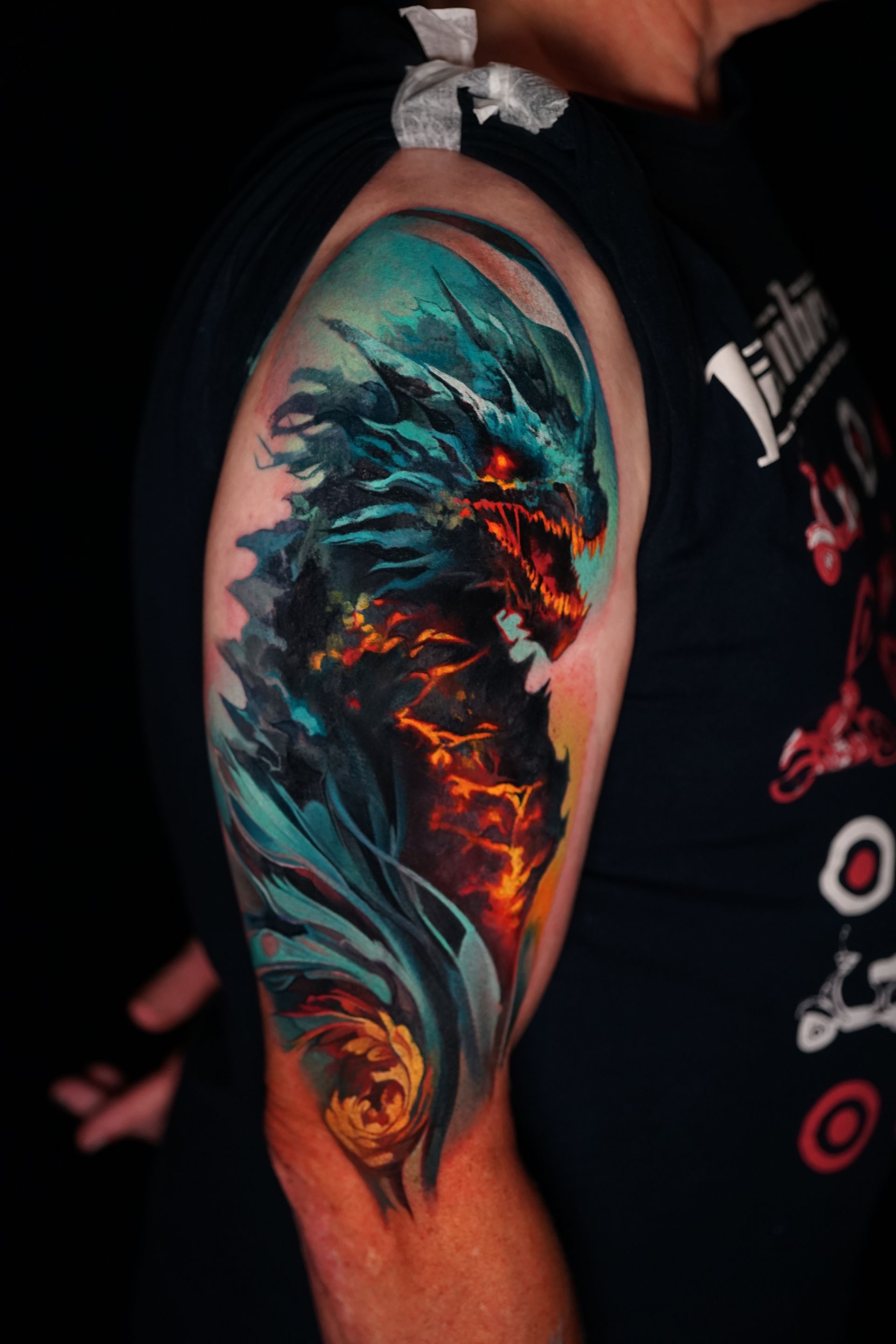 A man has a tattoo of a dragon on his arm.