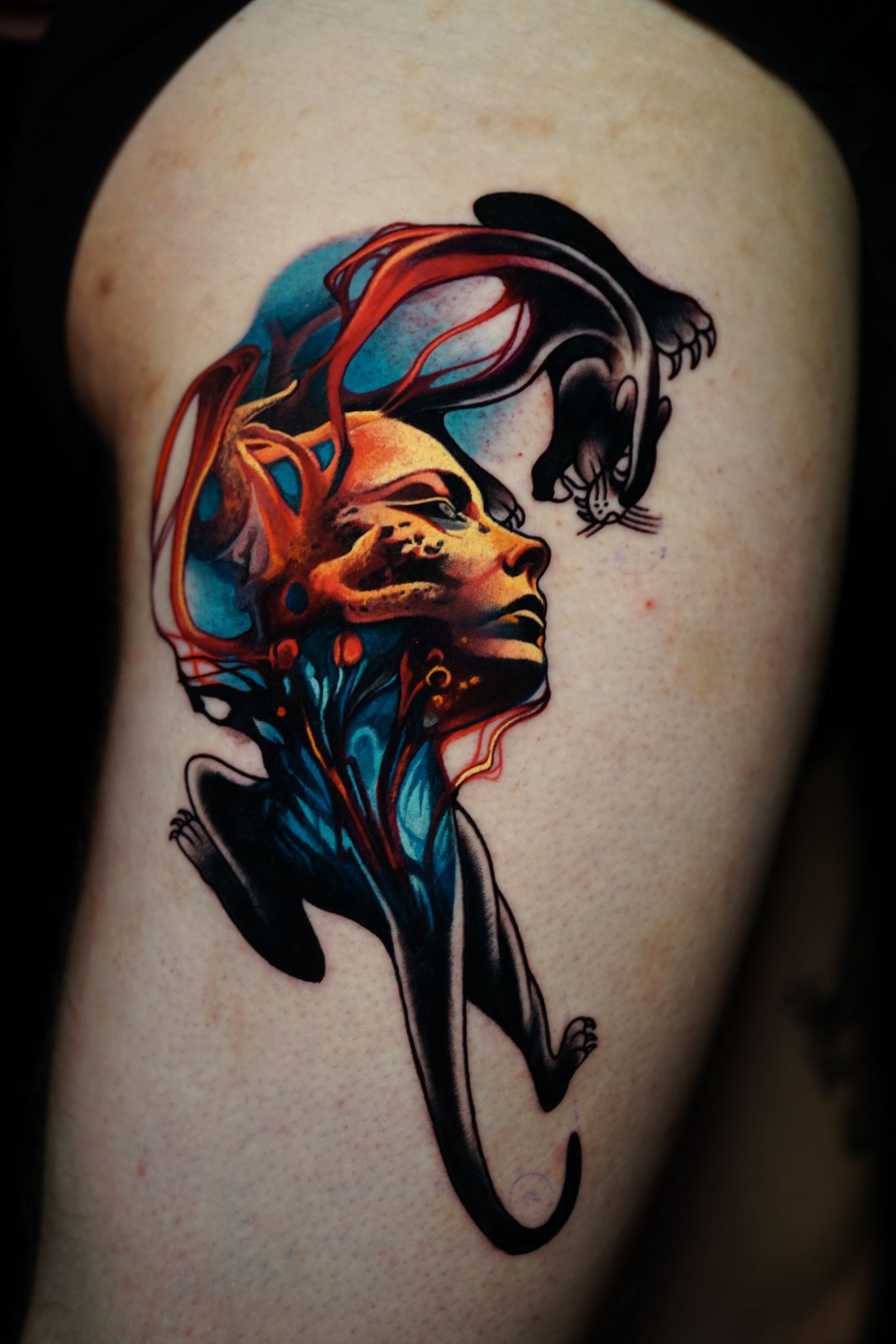 A colorful tattoo of a woman 's face and a panther