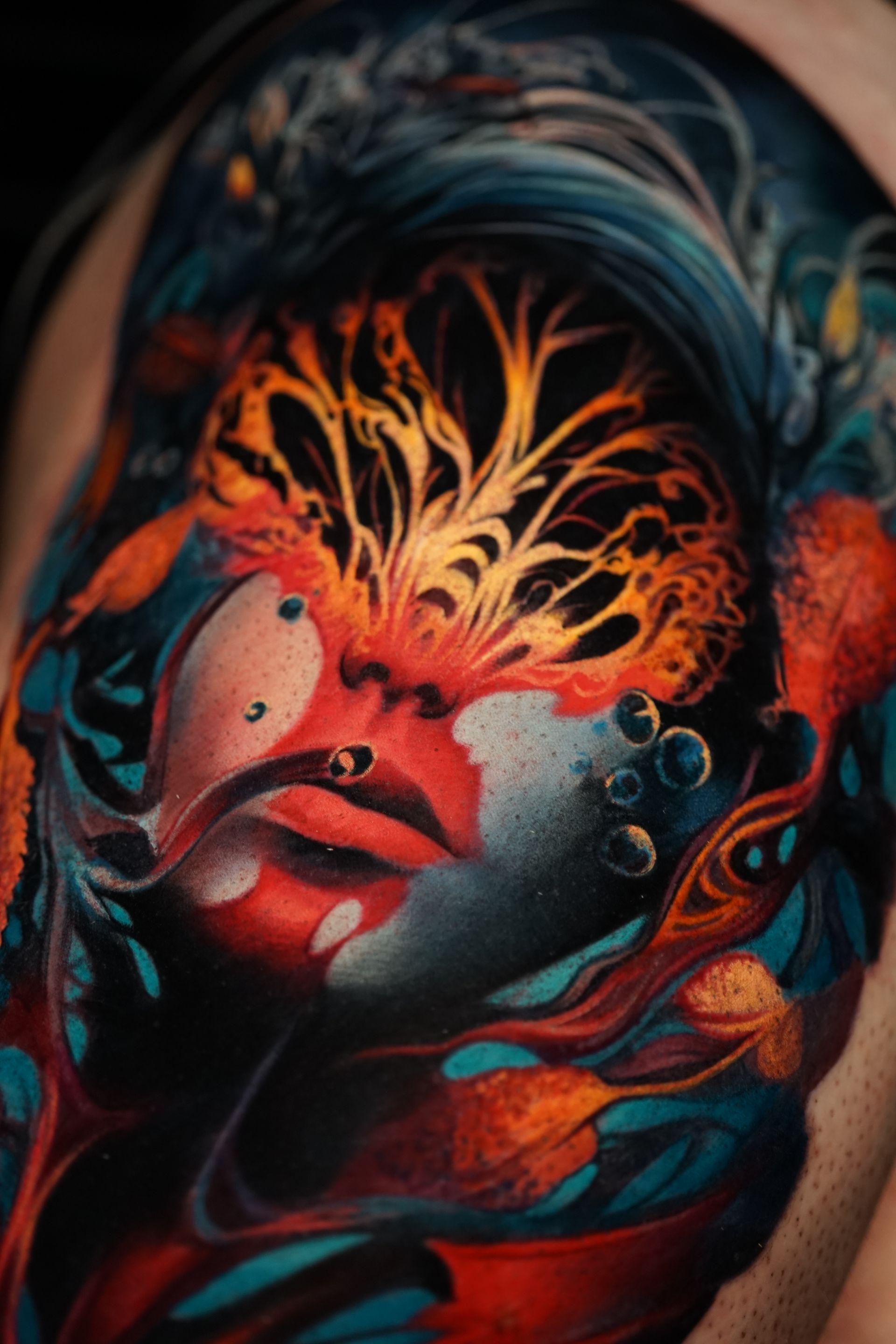 A close up of a colorful tattoo of a woman 's face on a man 's arm.