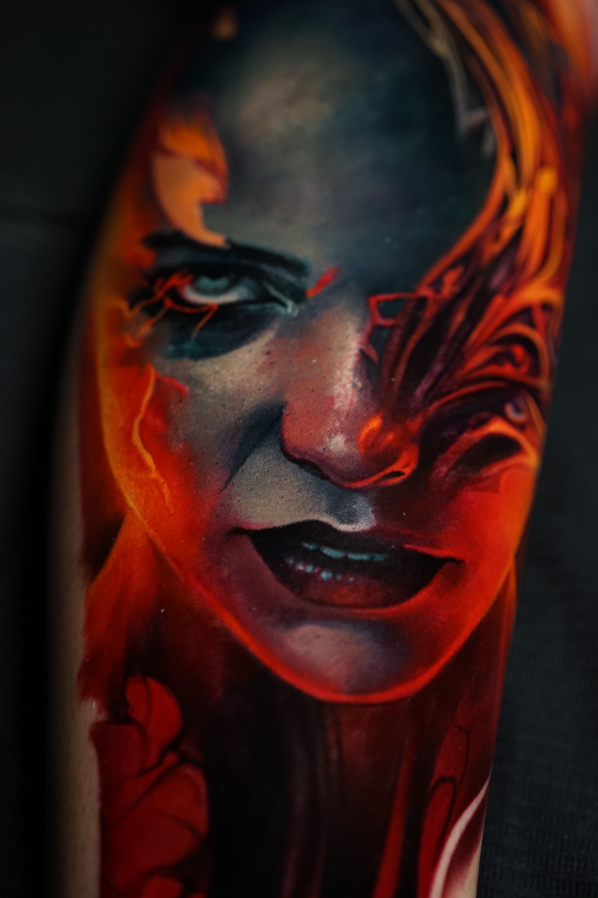 A close up of a colorful tattoo of a woman 's face.