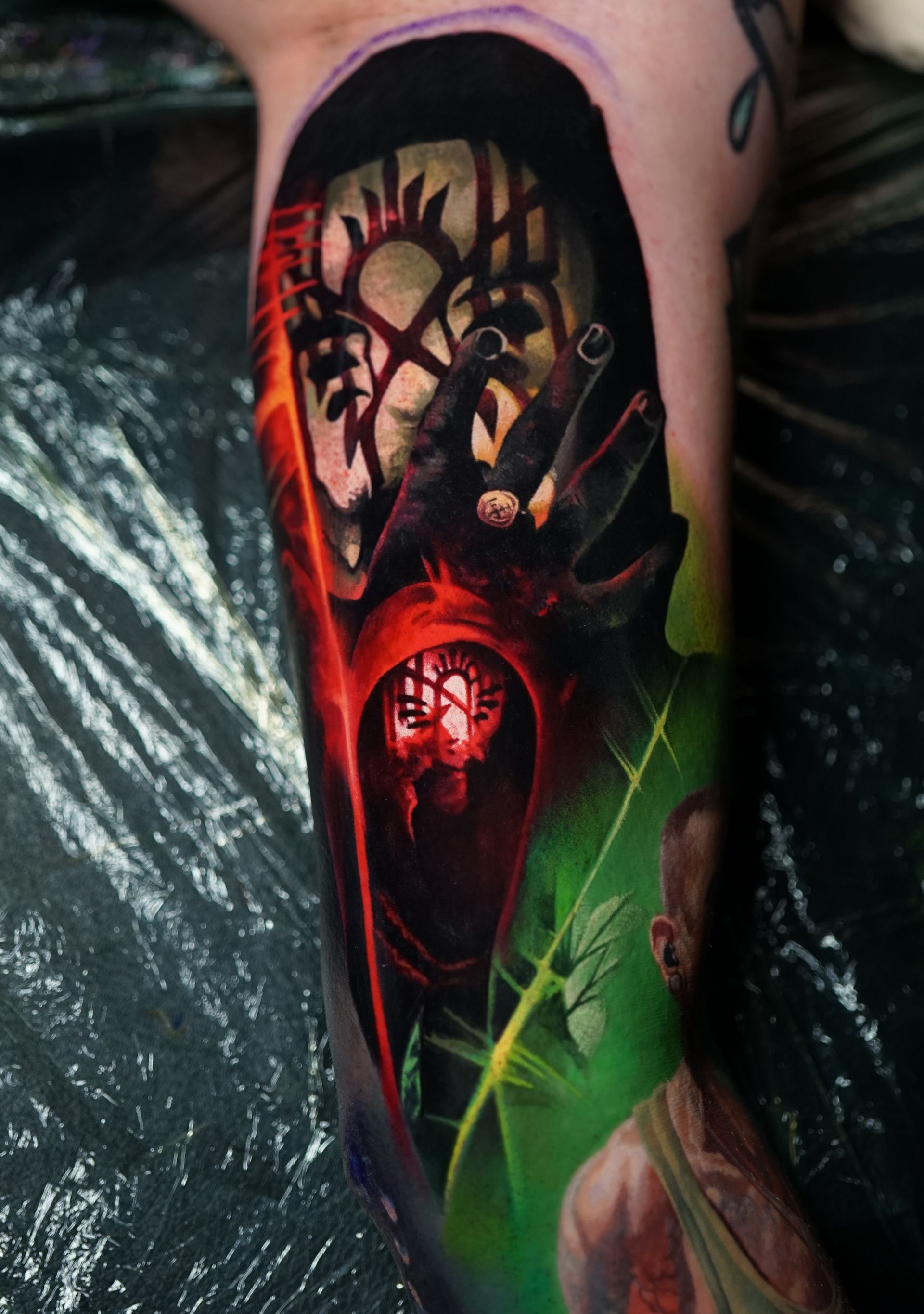 A person has a tattoo on their leg that looks like a painting