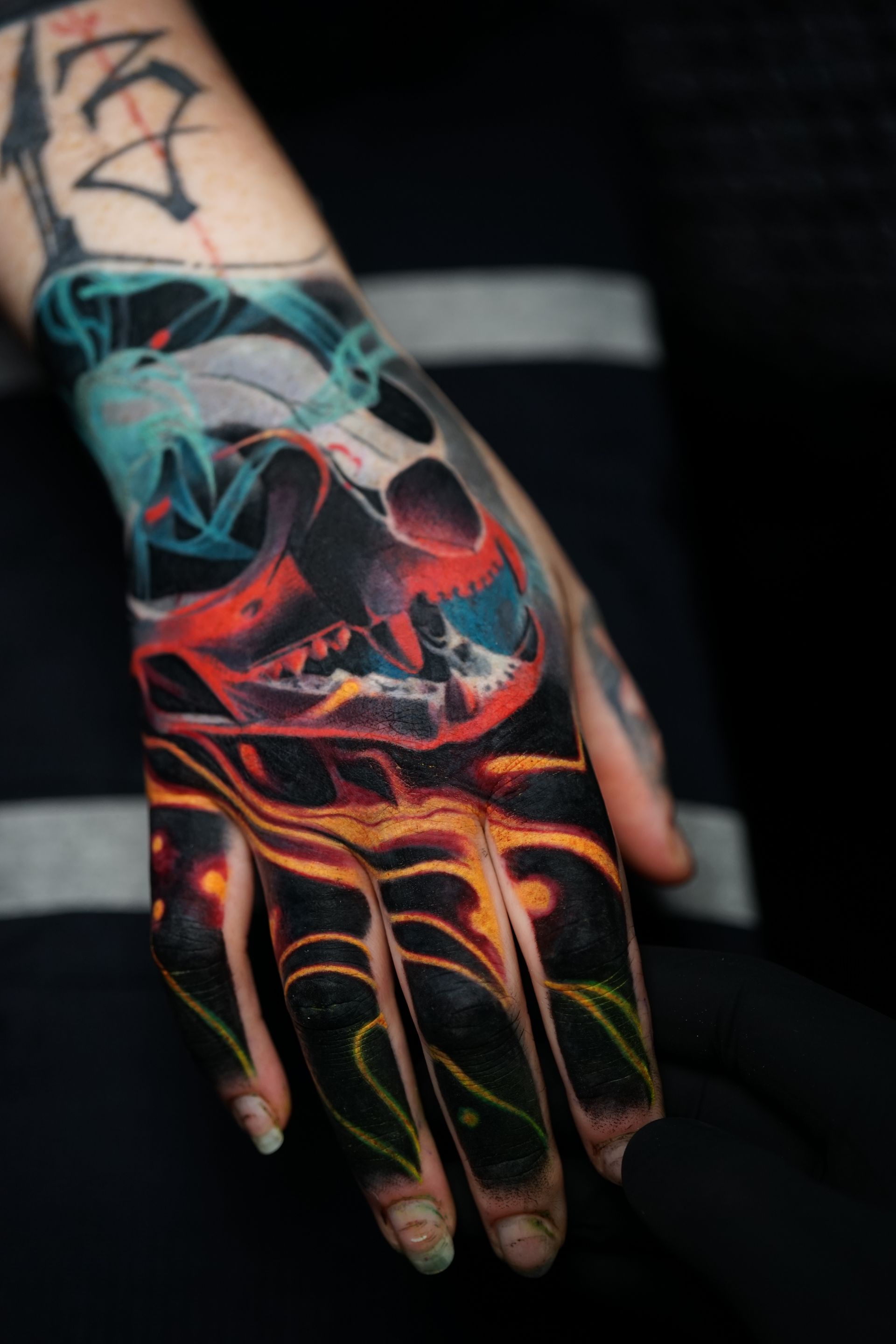 A close up of a person 's hand with a skull tattoo on it.