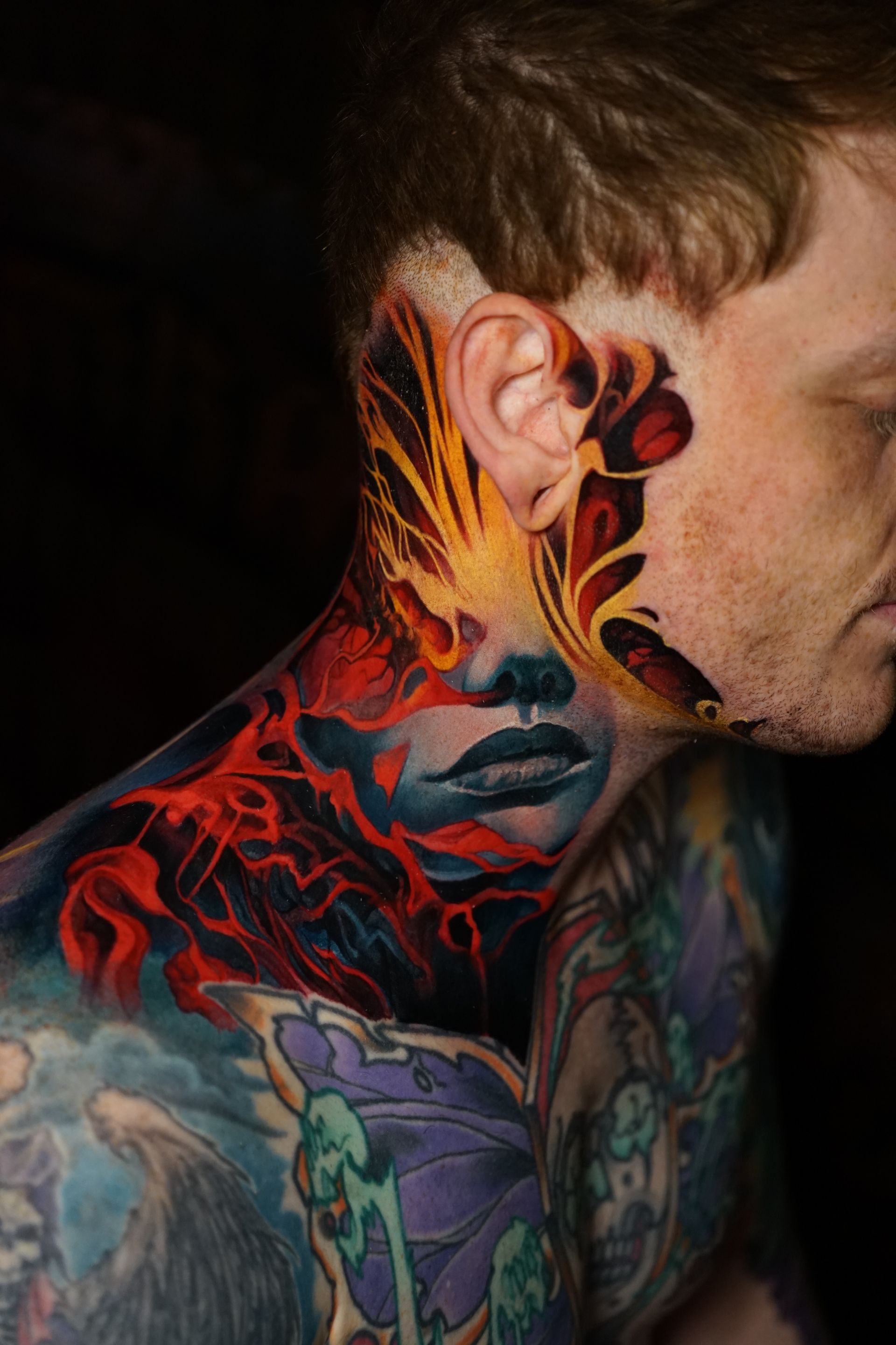 A man with a tattoo on his face and neck.
