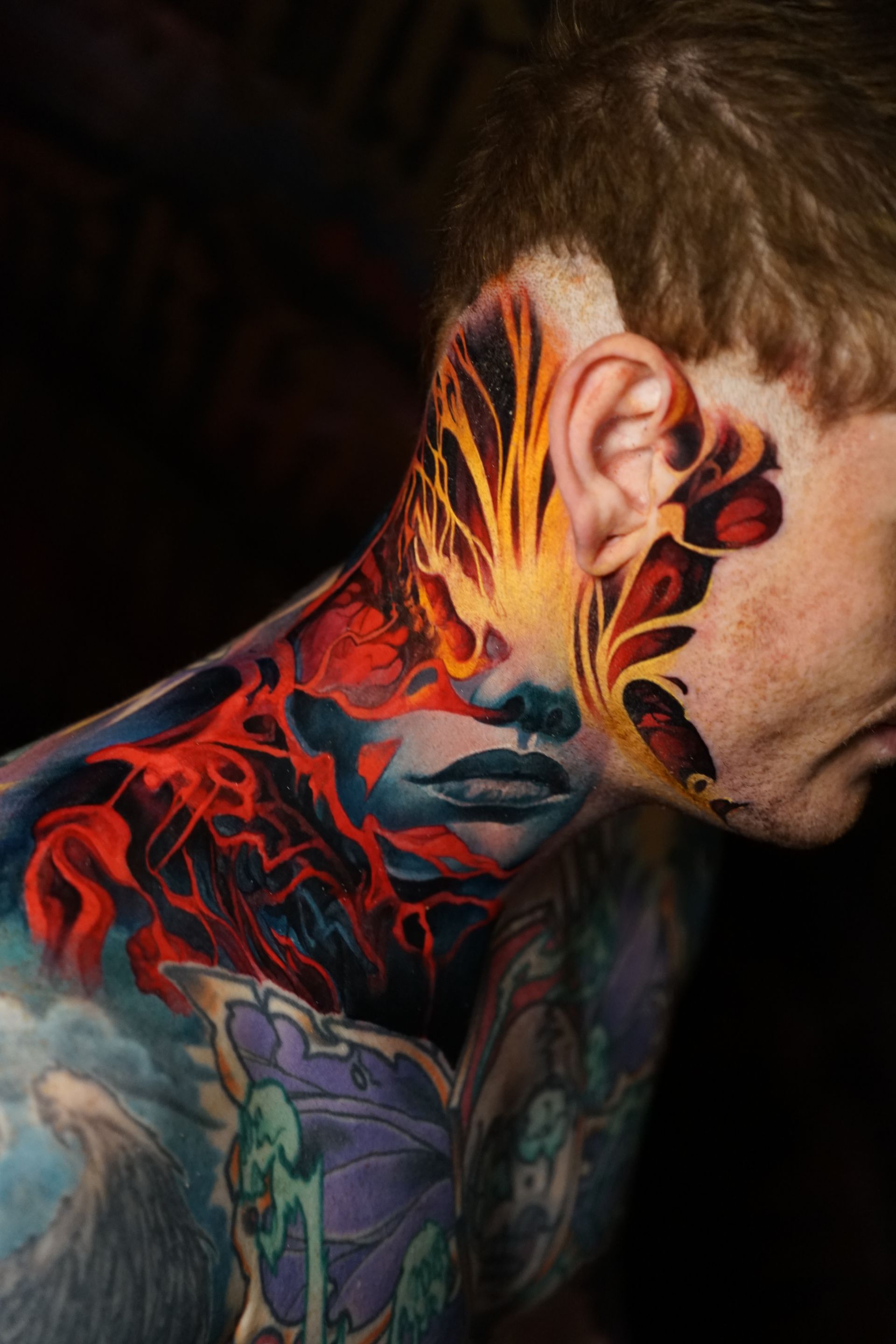 A man with a lot of tattoos on his face and neck.