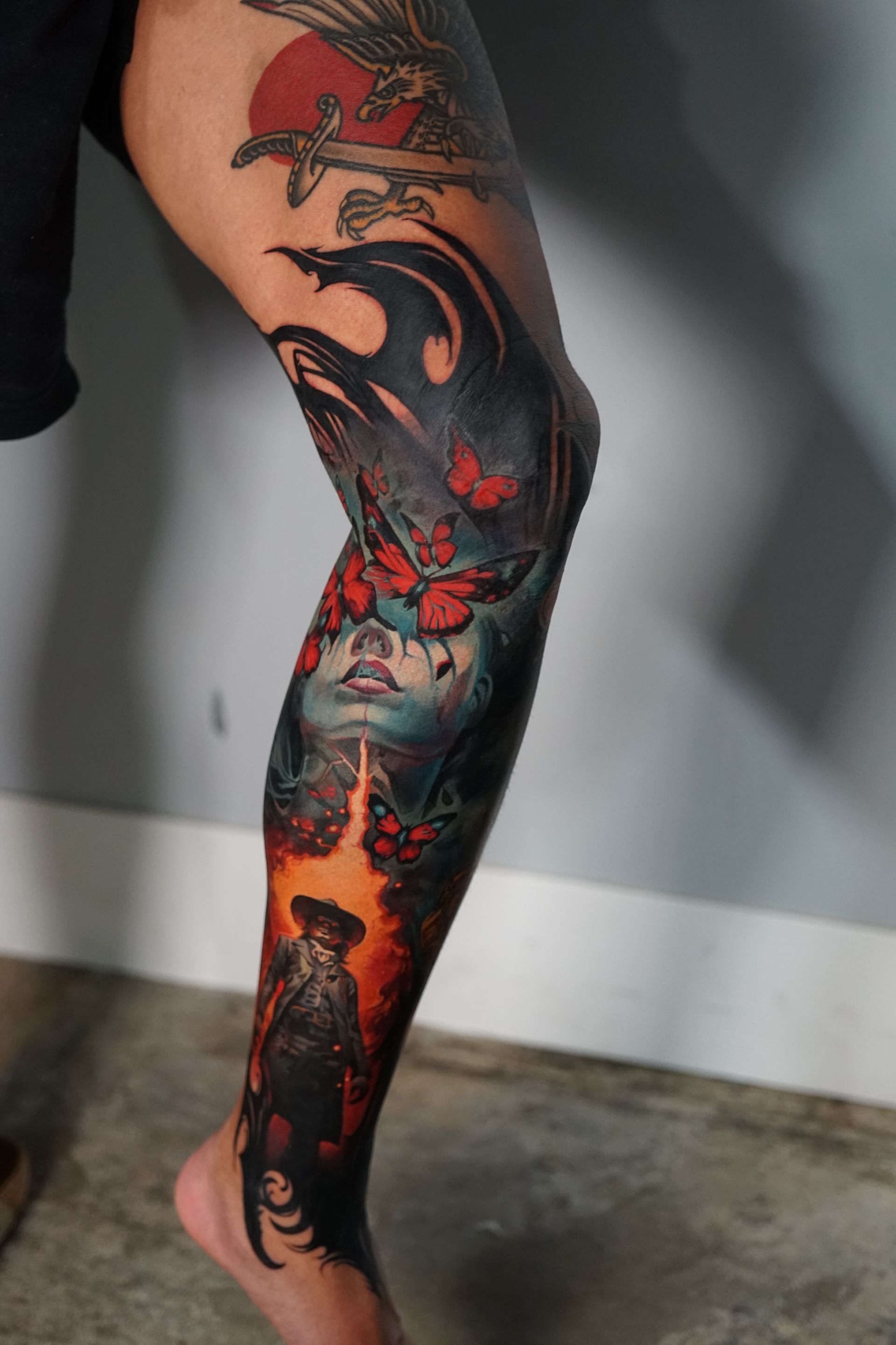 A person with a tattoo on their leg that looks like a painting