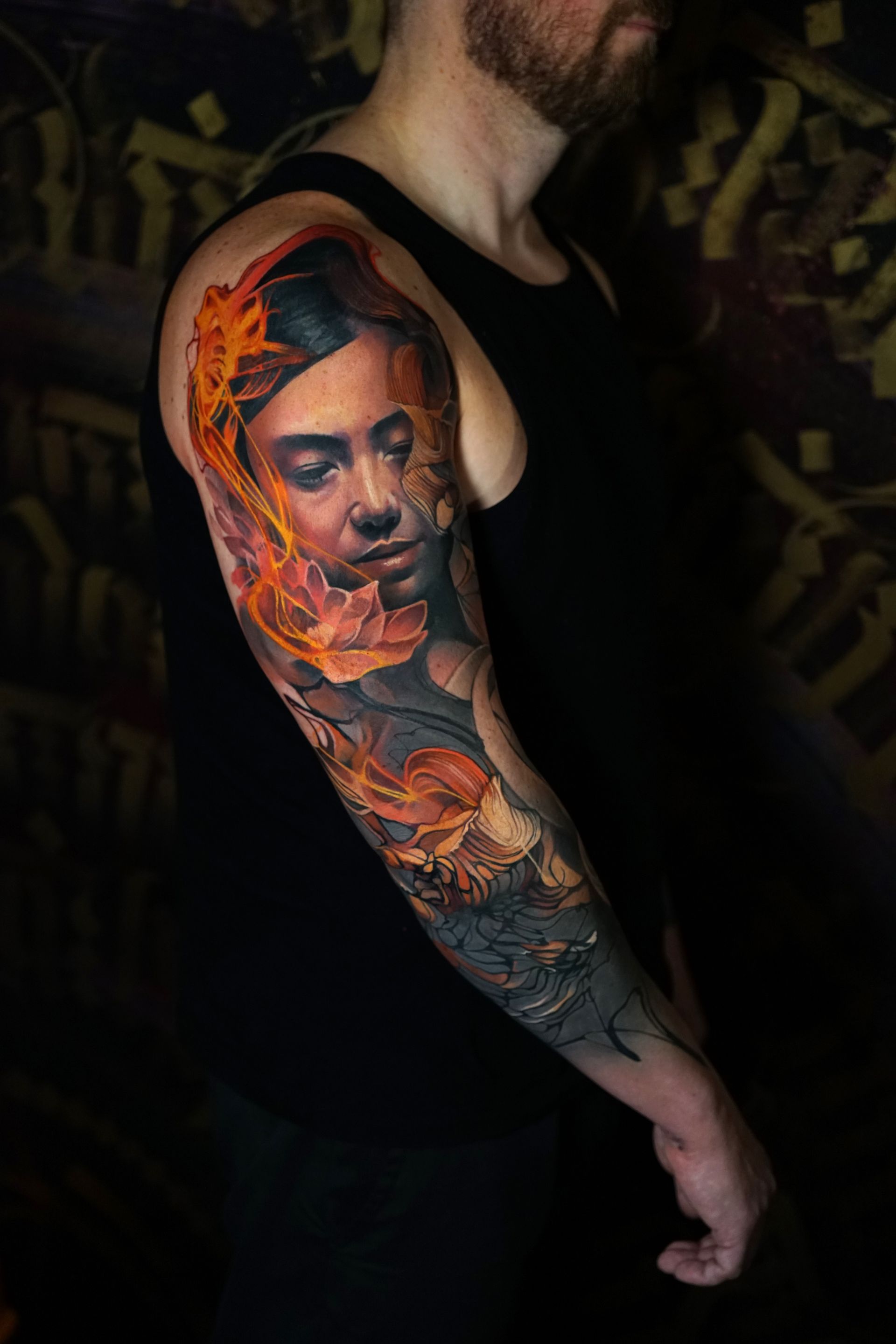 A man has a tattoo of a woman on his arm.