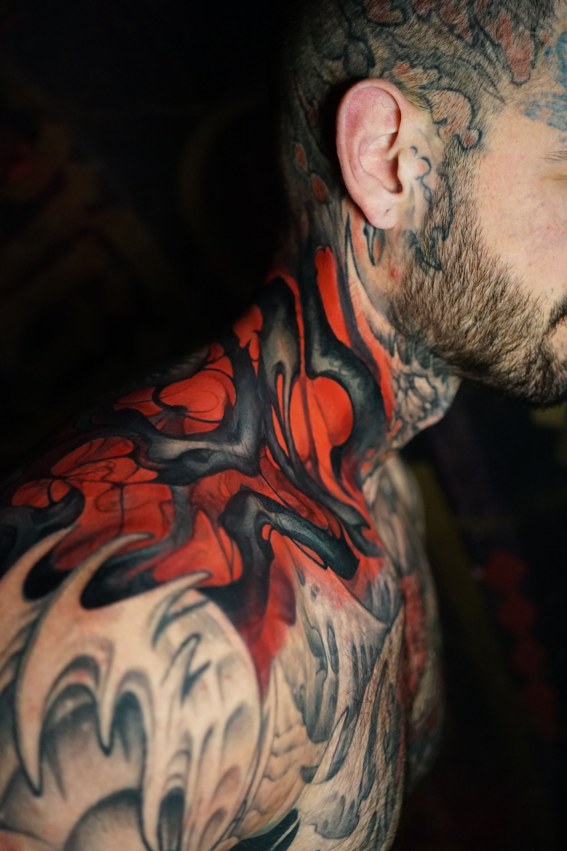 A man with a lot of tattoos on his neck and shoulder.