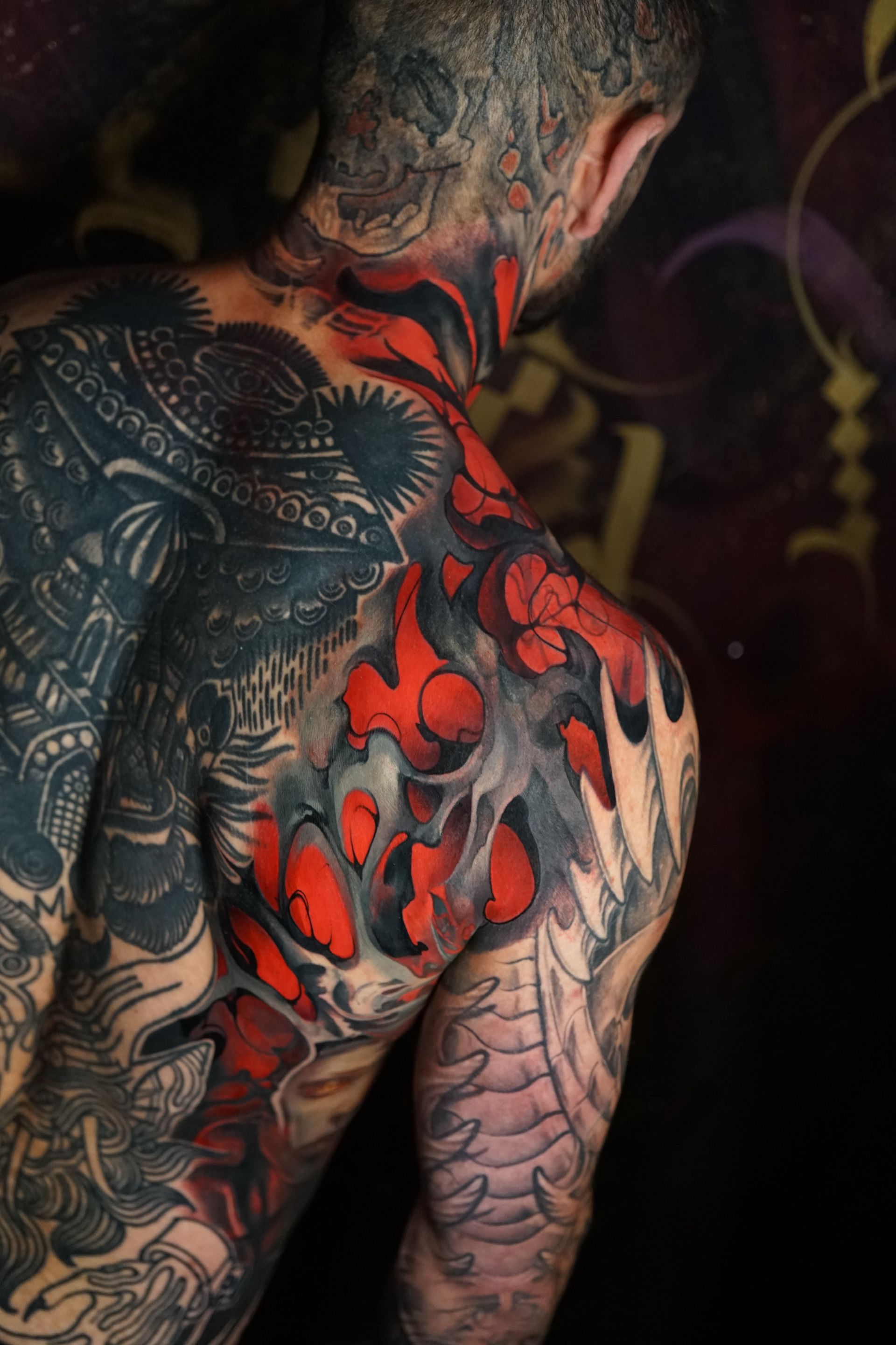 A man with a lot of tattoos on his back and neck