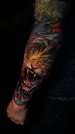 A person has a colorful tattoo of a lion on their arm.