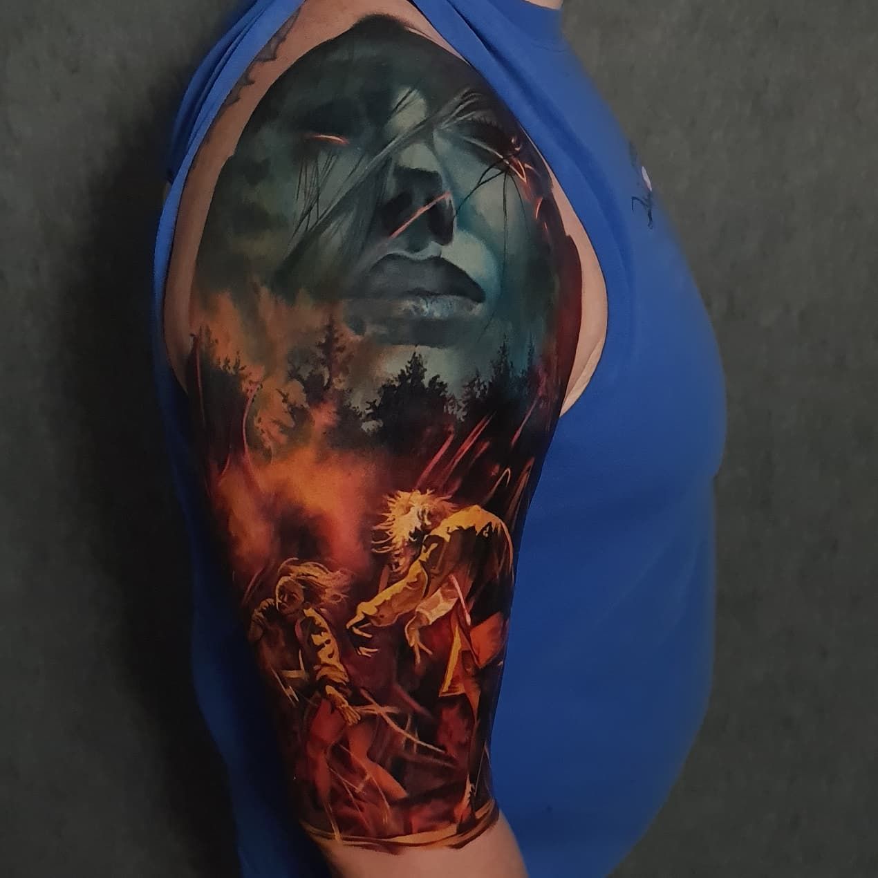 A woman has a tattoo of a man 's face on her arm