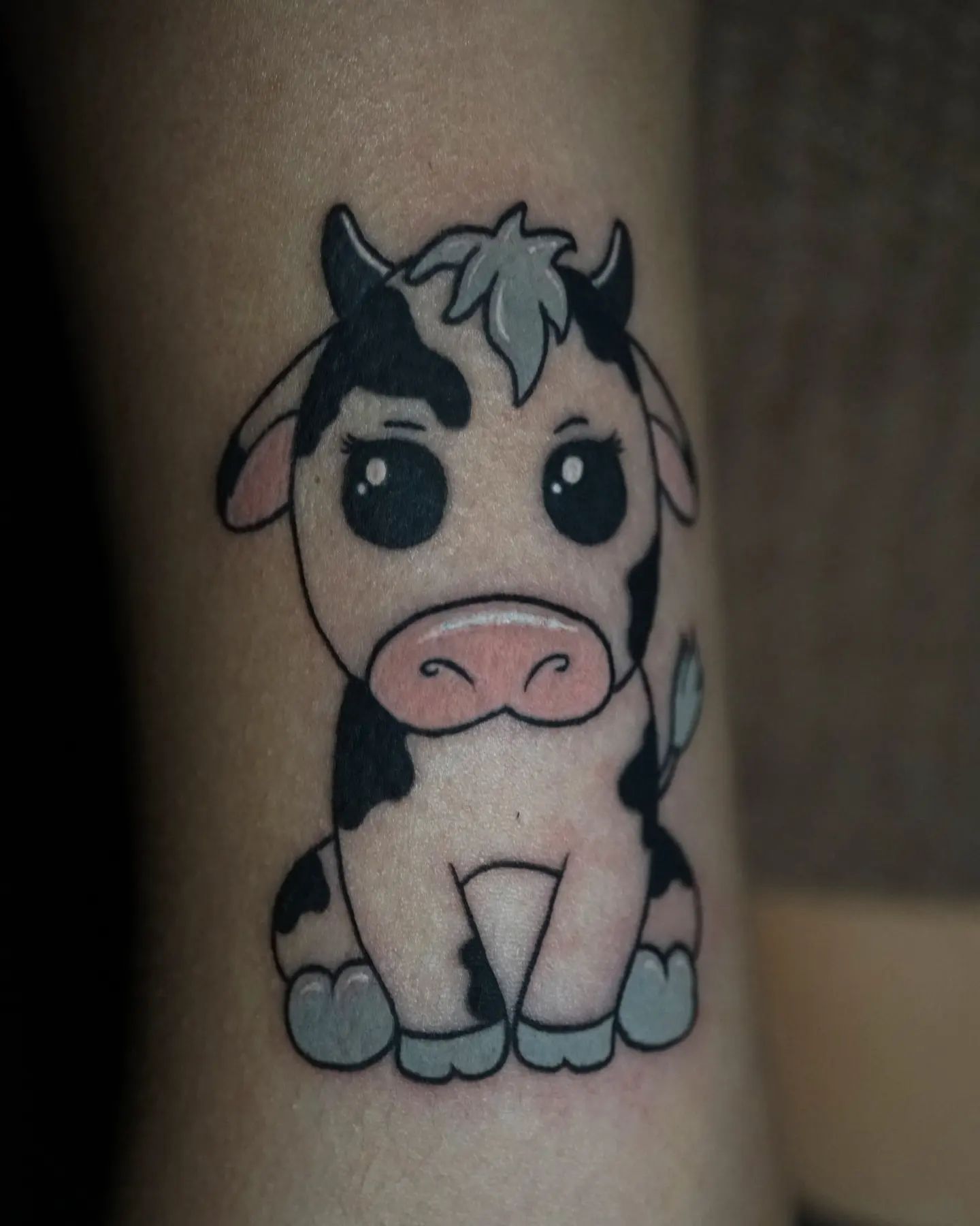 A tattoo of a cow on a person 's leg