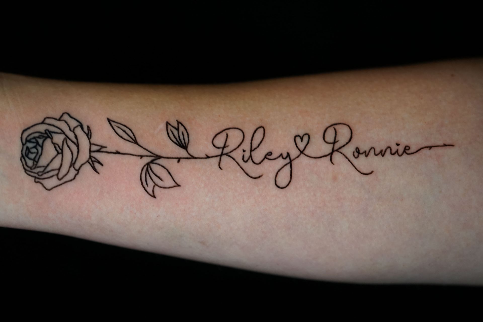 A tattoo of a rose and the name riley ronnie