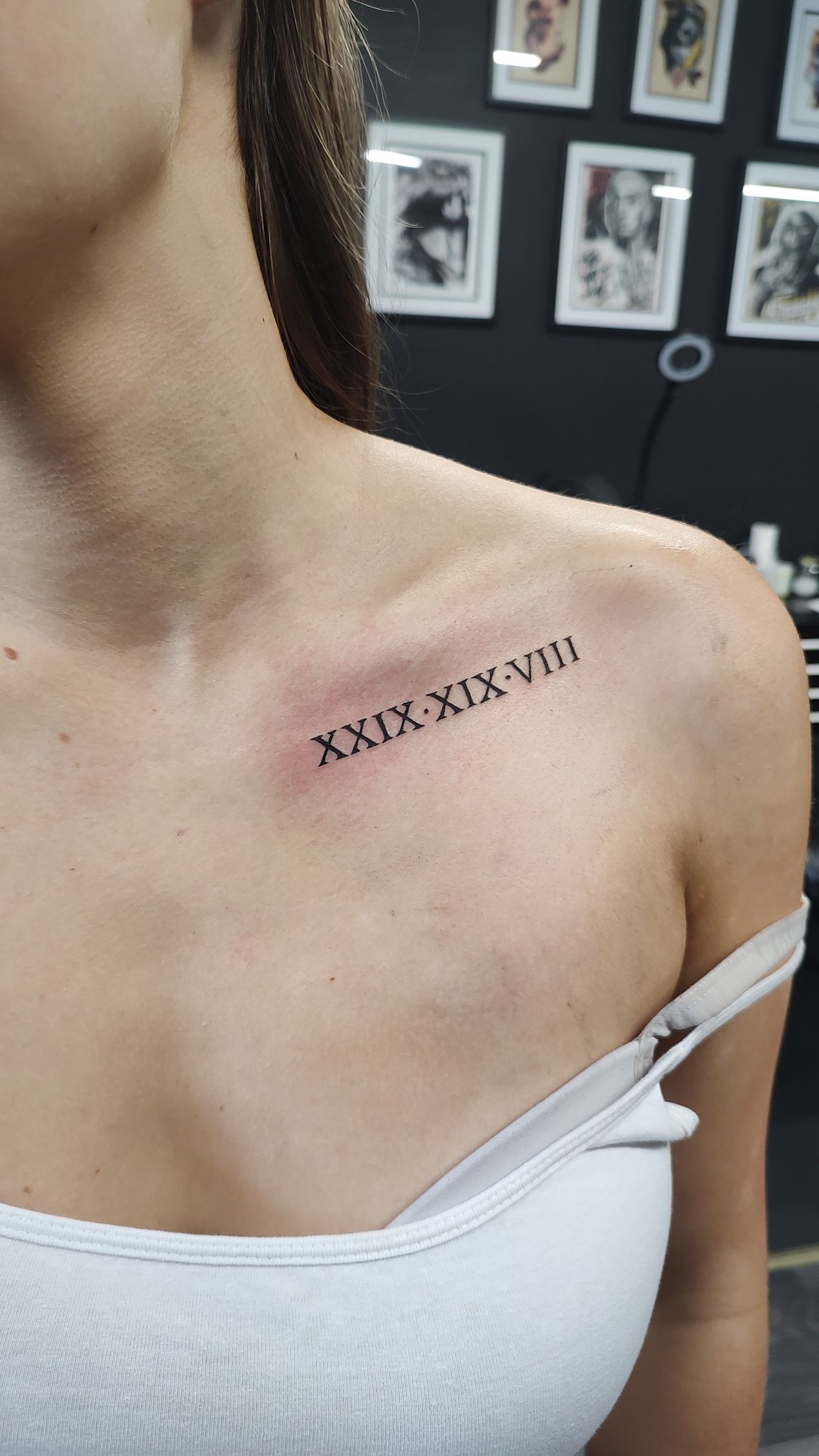 A woman has a tattoo of roman numerals on her chest.