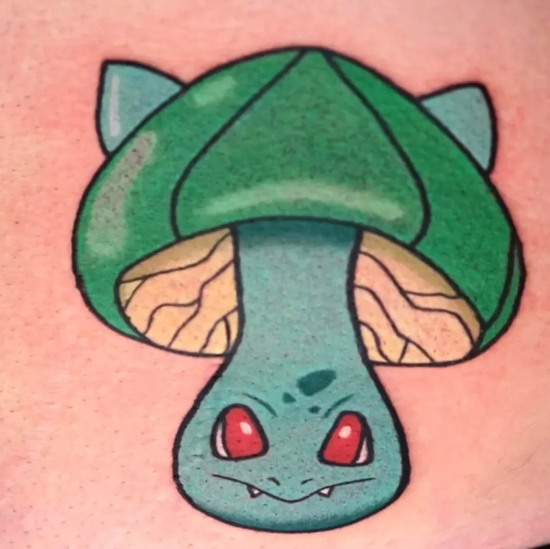 A tattoo of a green mushroom with red eyes