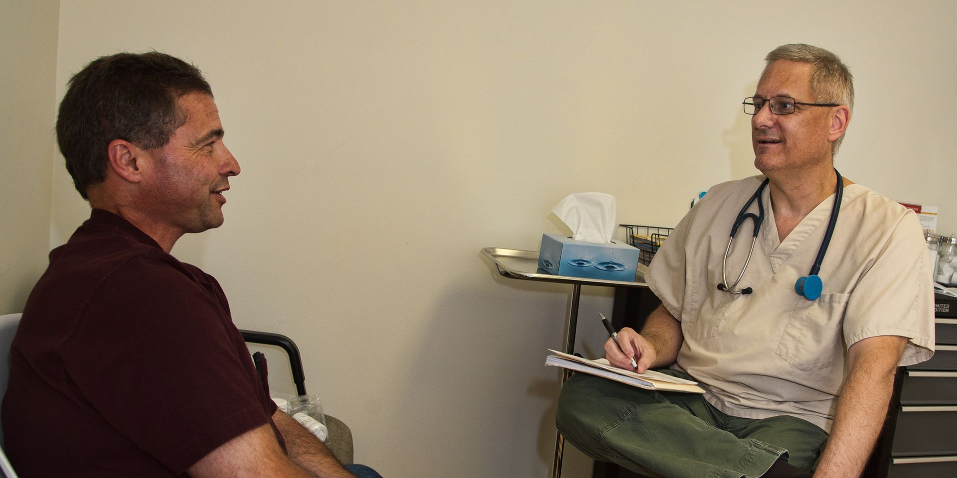 man and patient in clinic talking