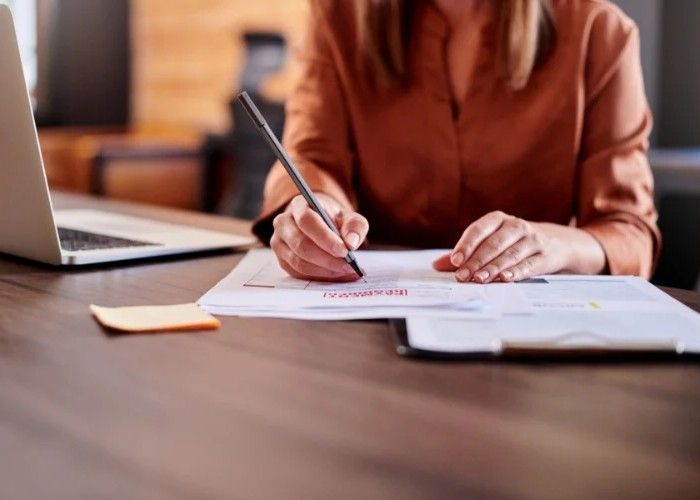 Three medical professionals smiling during a discussion. Two are wearing scrubs, one has a lab coat.