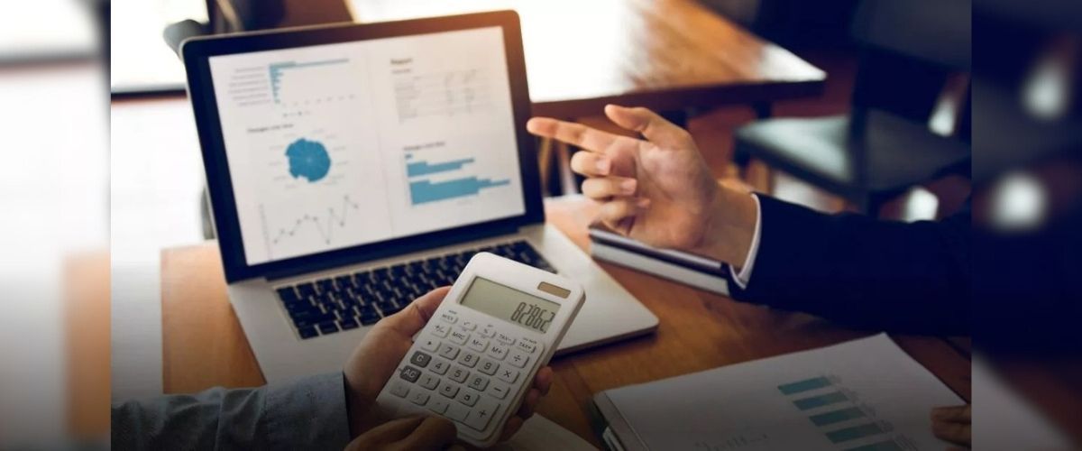 Medical team with hands stacked in a show of unity, wearing white coats and scrubs.