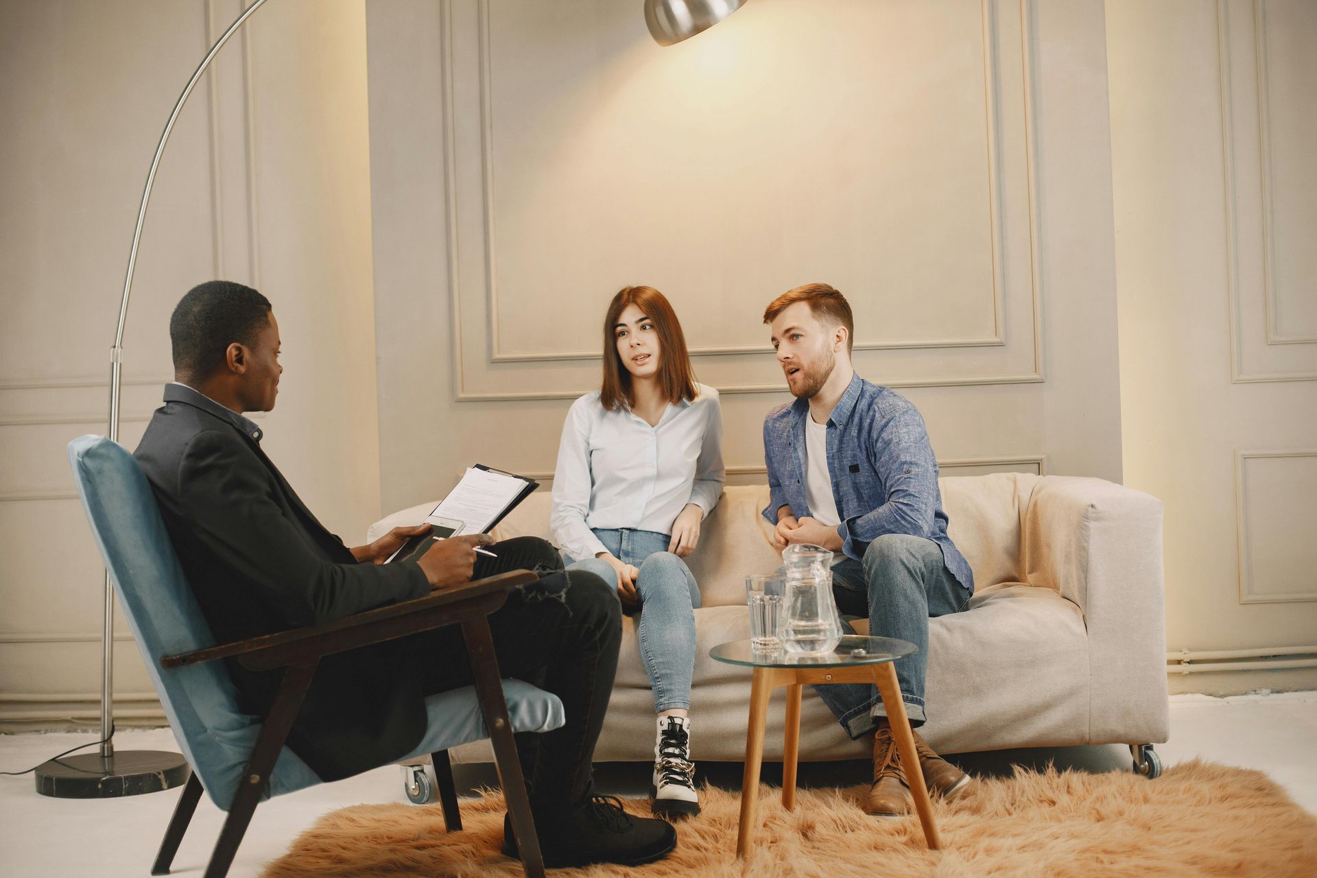 A woman is writing on a clipboard while sitting next to a man.
