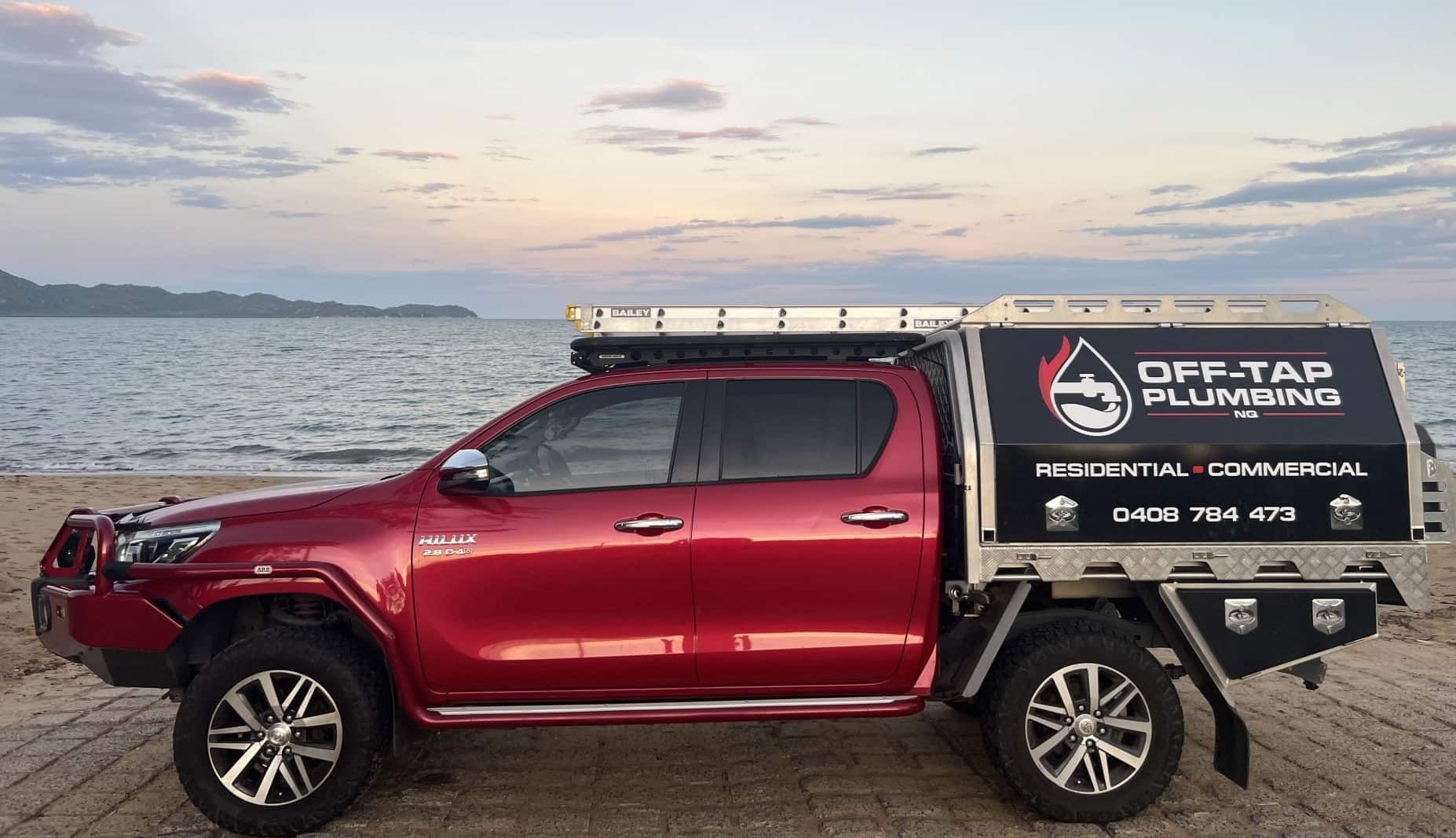 Red Truck With a Canopy is Parked on the Beach — Off-Tap Plumbing NQ In Currajong, QLD