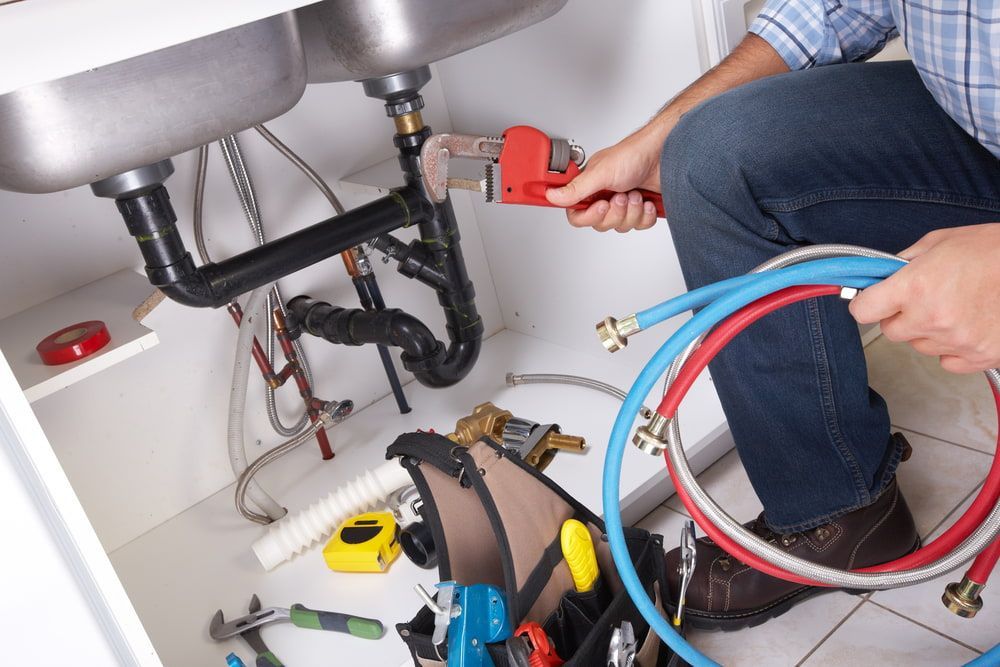 Plumber is Fixing a Sink With a Wrench — Off-Tap Plumbing NQ In Currajong, QLD