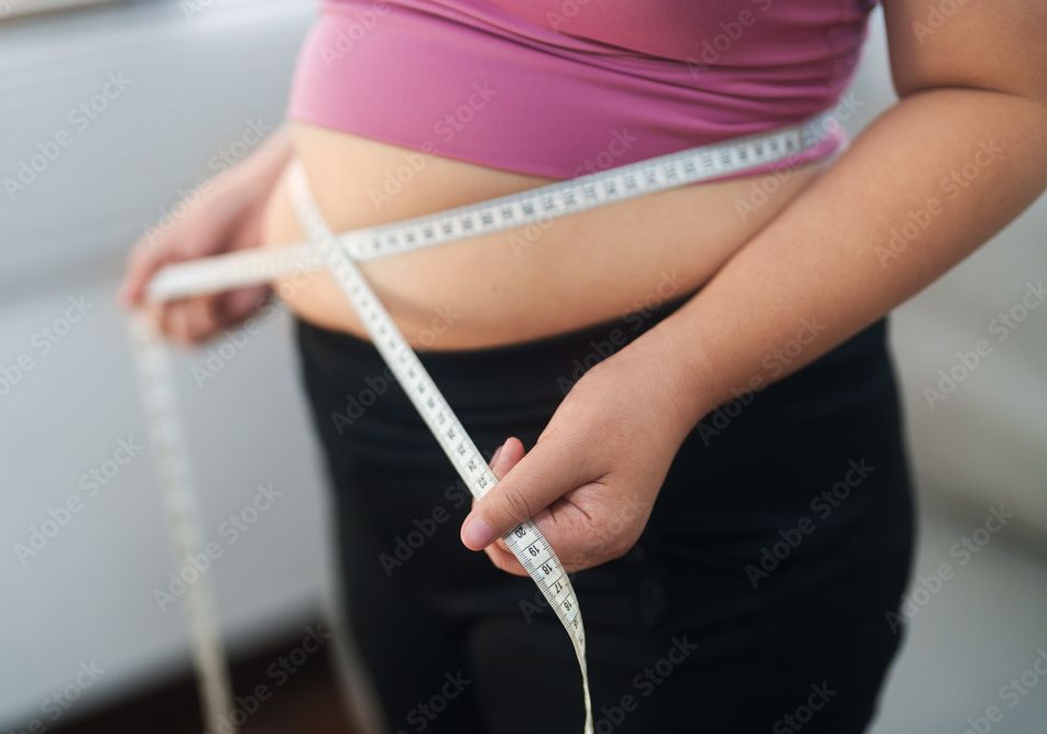A woman is laying in bed with her hand on her forehead.