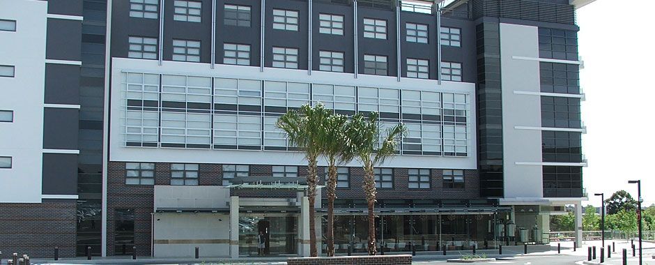 Large Building With A Lot Of Windows And Palm Trees In Front — Atherton Glass In Atherton, QLD