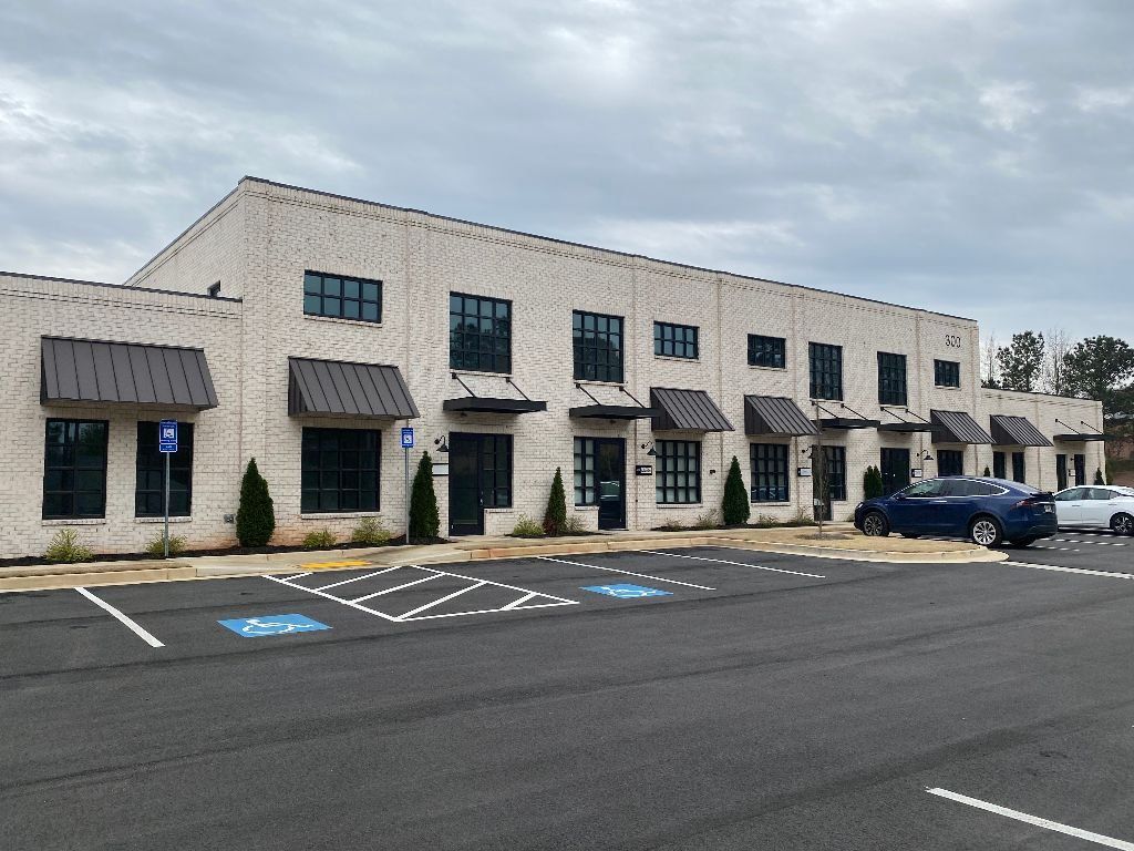 A large white building with a parking lot in front of it.