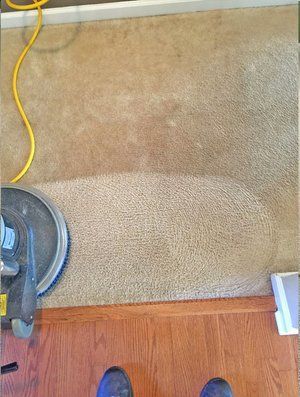 A person is standing on a wooden floor next to a vacuum cleaner.