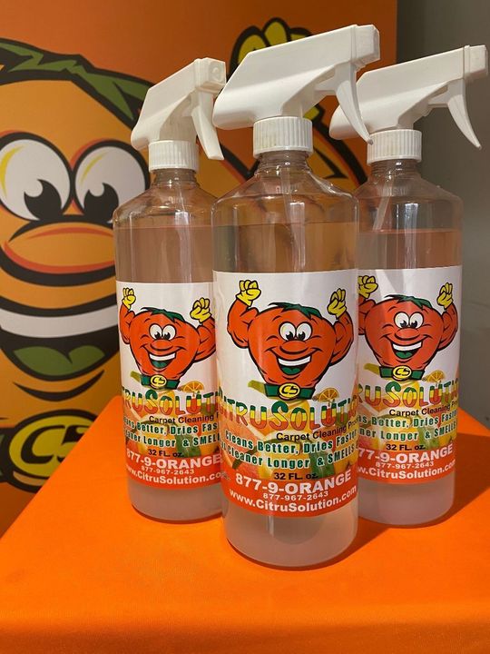 Three spray bottles with a cartoon orange on the label