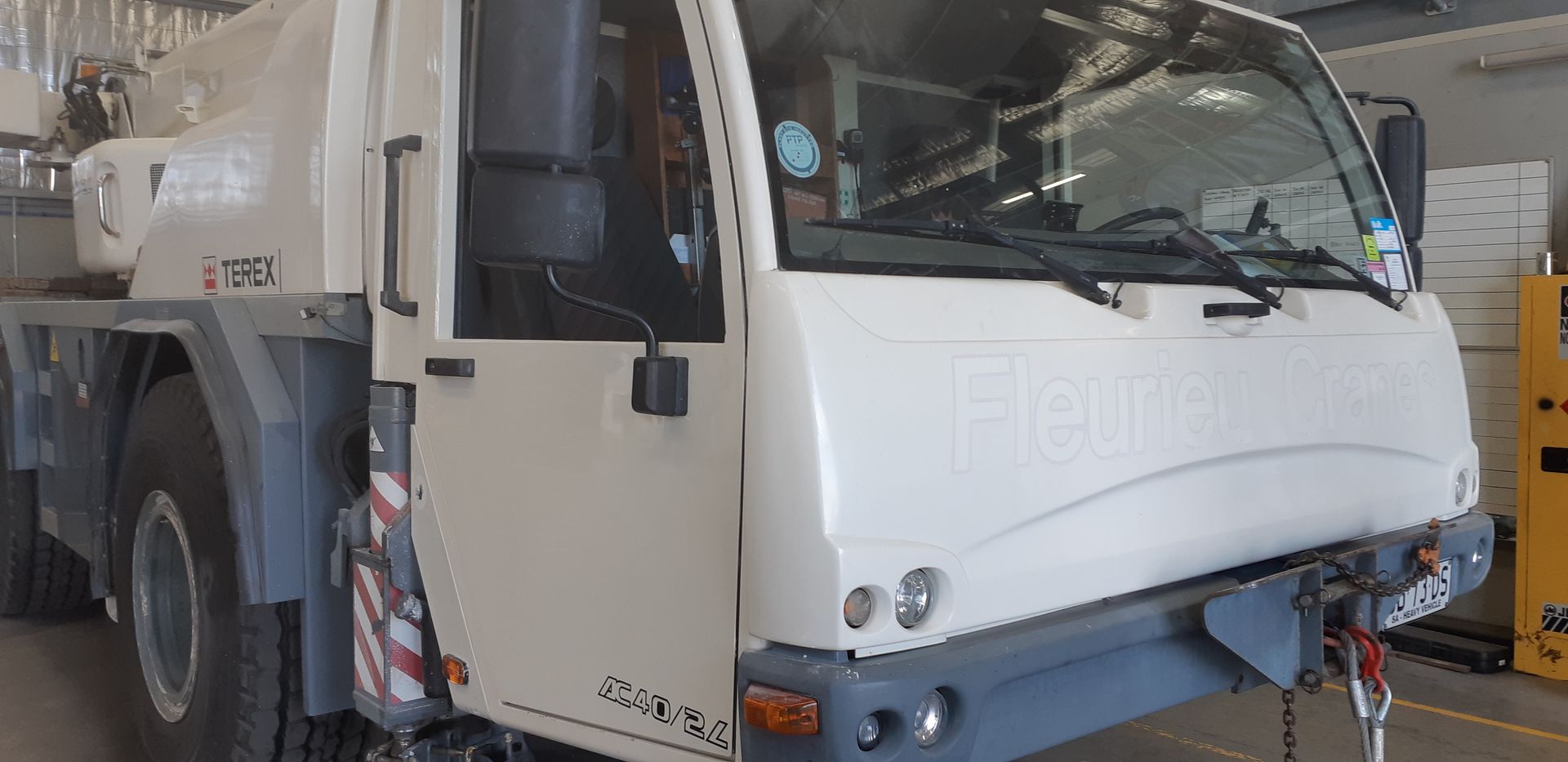 A large white truck is parked in a garage.