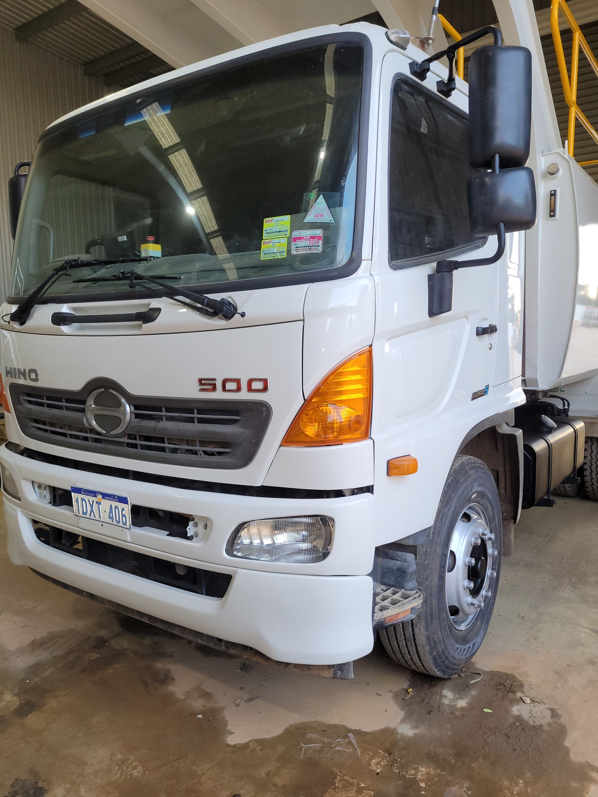 A white truck is parked in a garage.