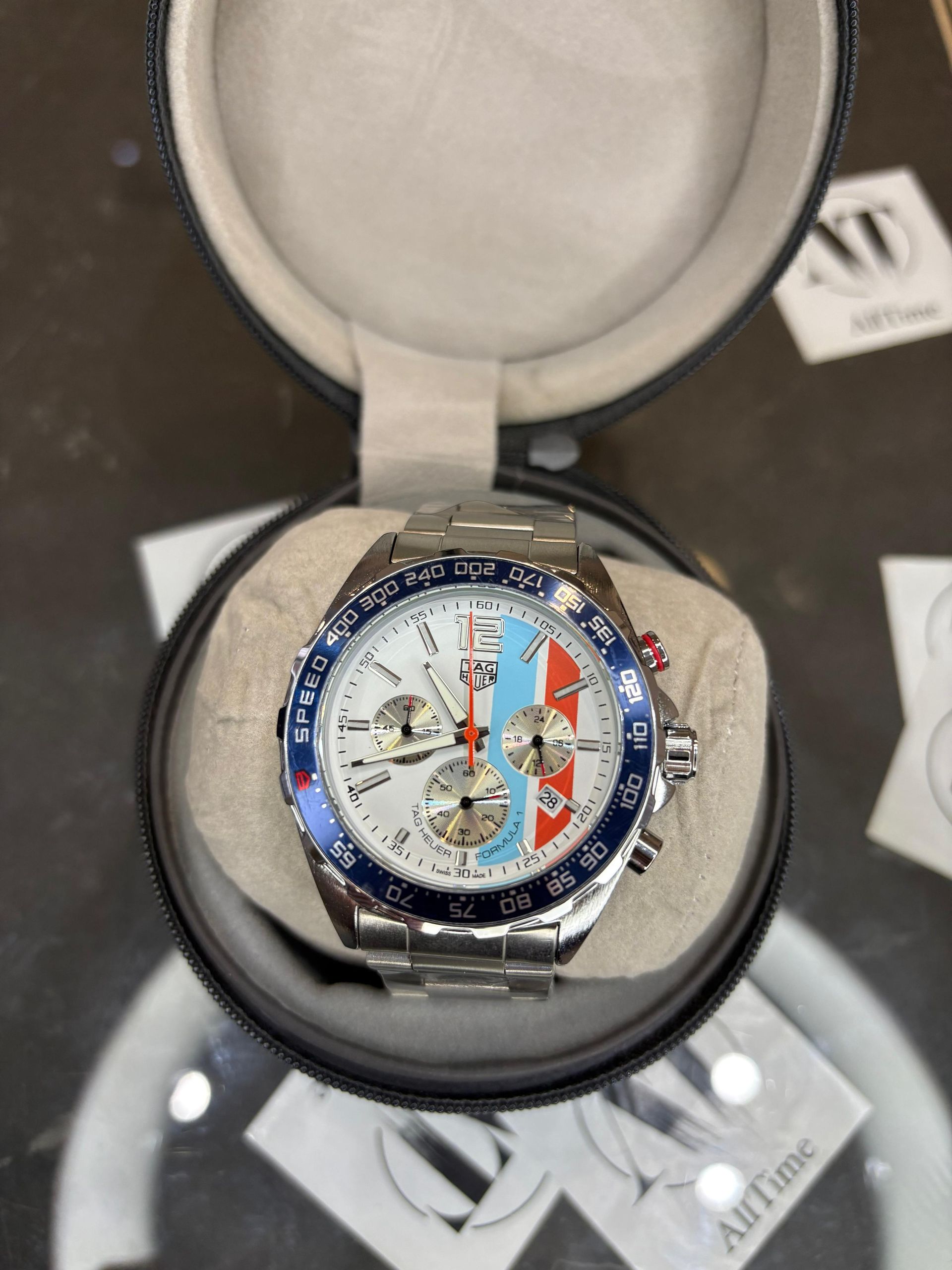 Un reloj está dentro de un estuche sobre una mesa.