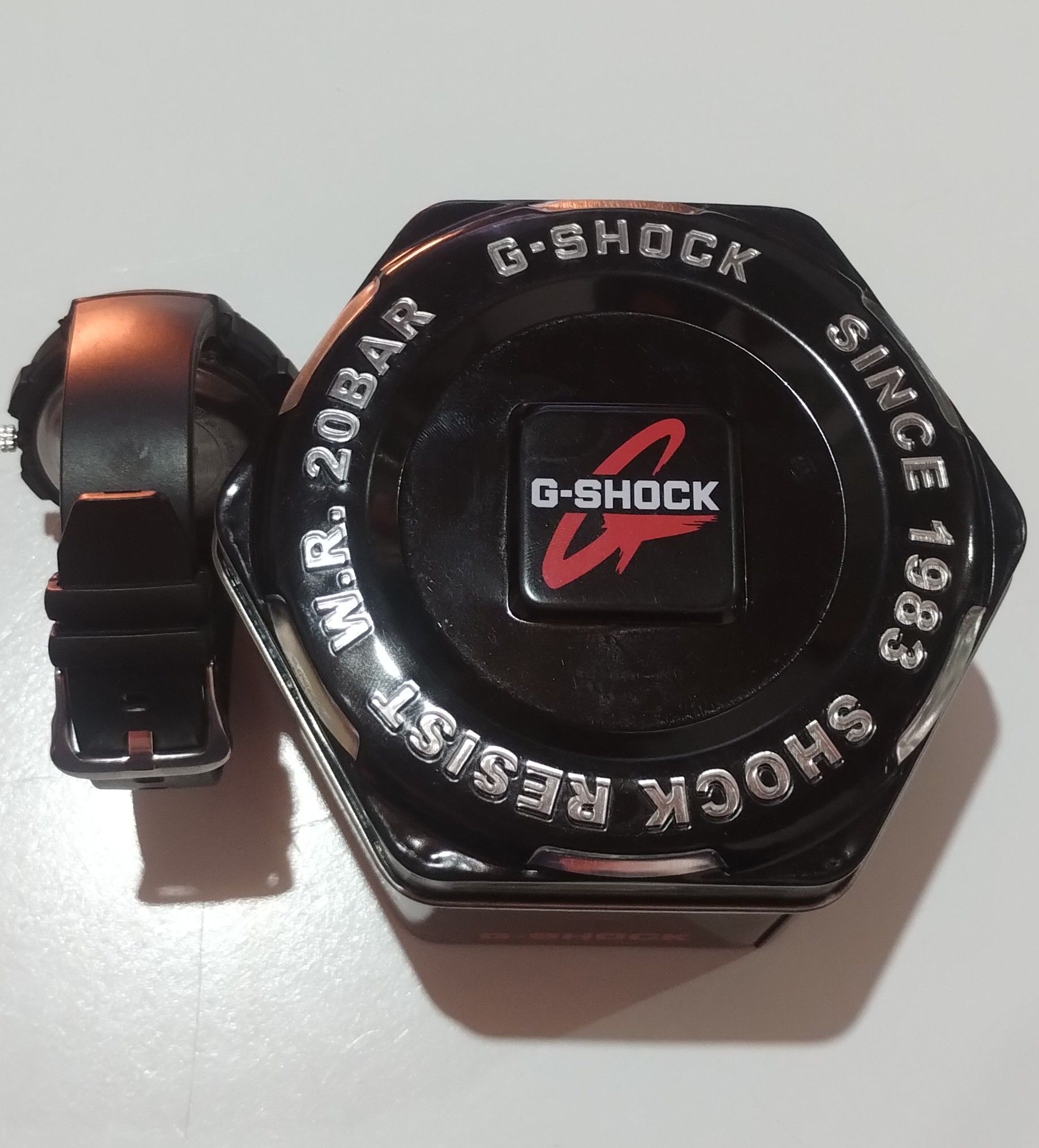 Un reloj G-Shock se encuentra sobre una superficie blanca.