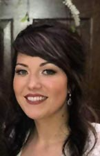 A close up of a woman 's face with a flower in her hair.
