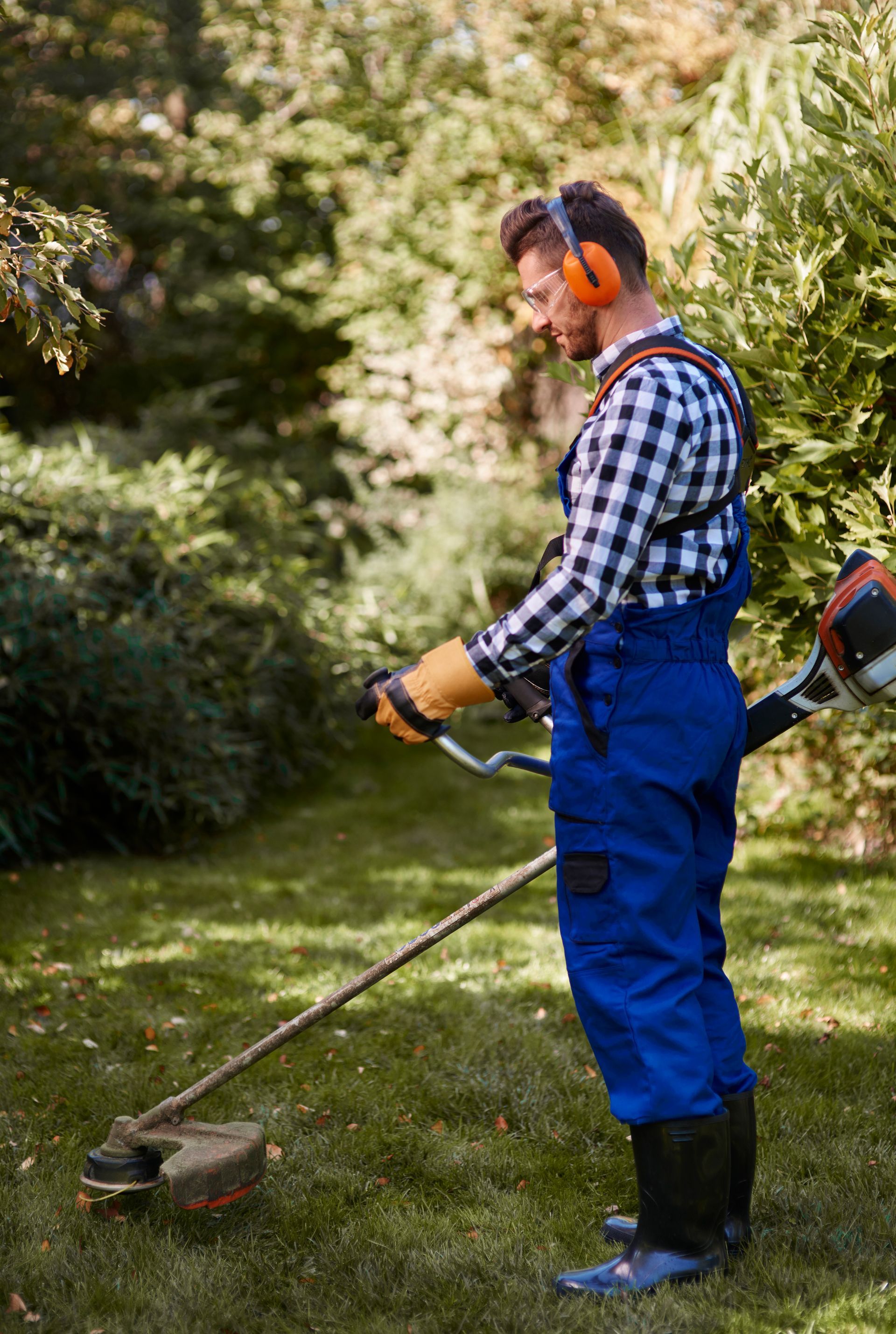 A man is using a lawn mower to cut the grass.