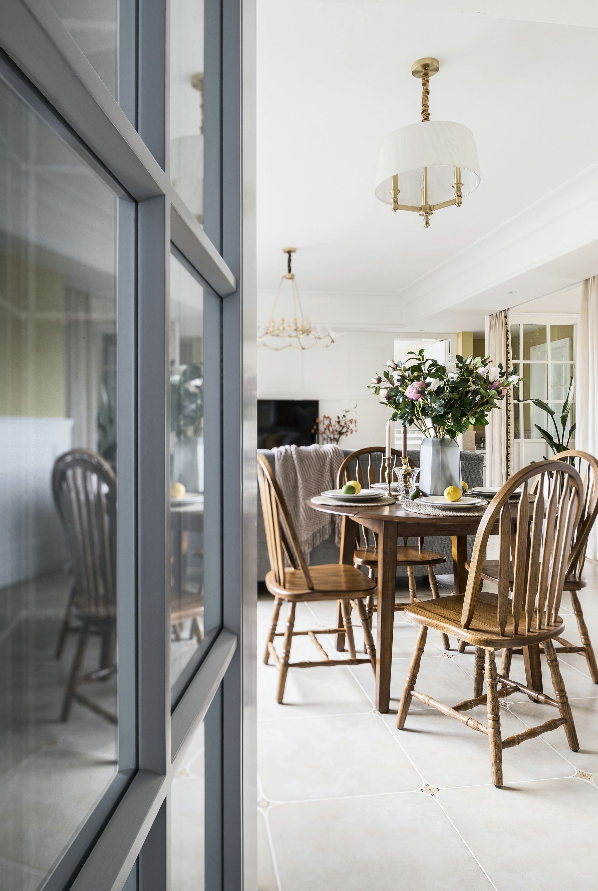 A dining room with a table and chairs and a window.