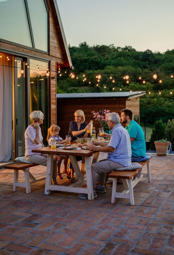 A group of people are sitting around a table on a patio.
