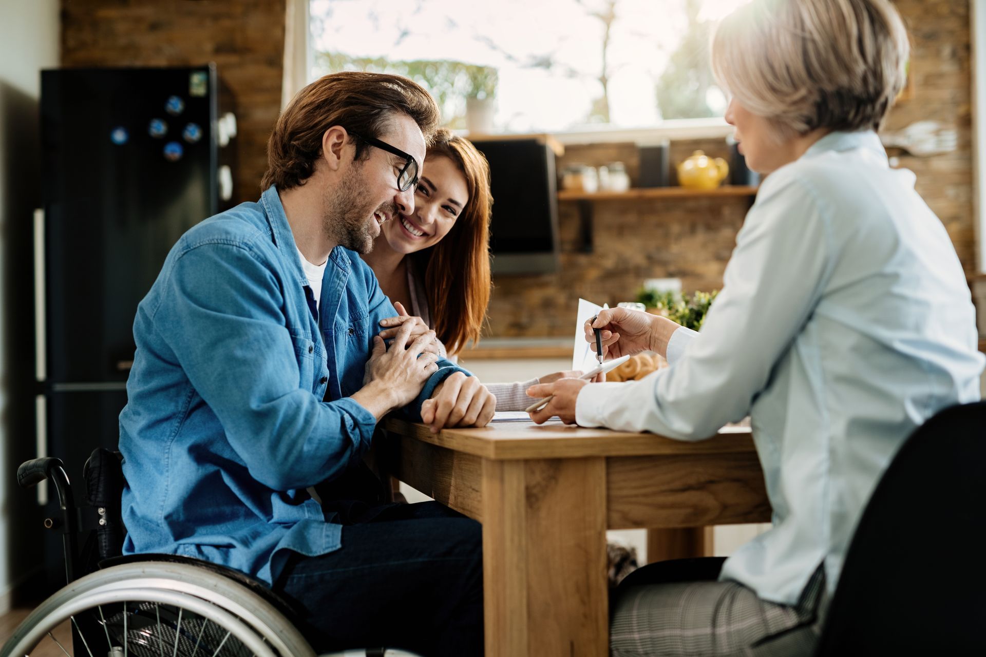 A man in a wheelchair is sitting at a table with a woman.