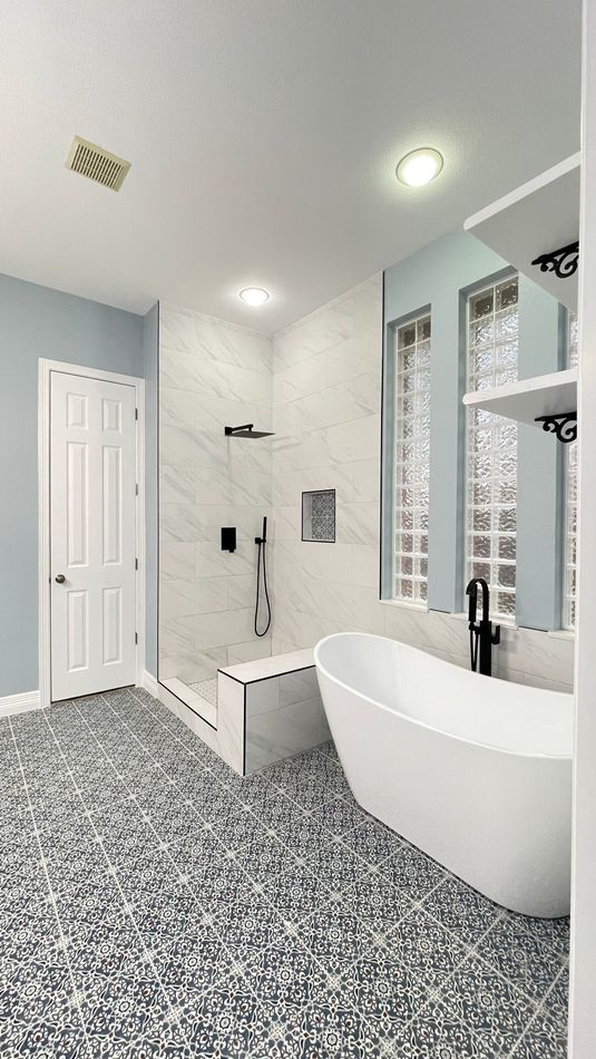 A bathroom with a tub , shower and mirror.