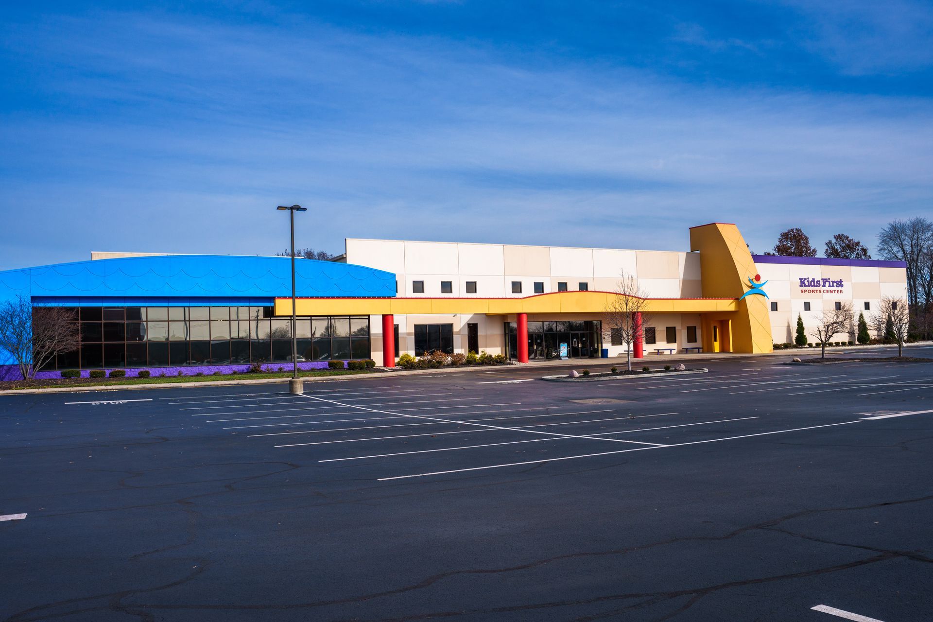 An aerial view of a large building with a parking lot in front of it.