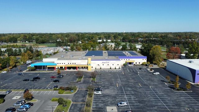 An aerial view of a large building with a parking lot in front of it.