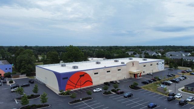 An aerial view of a large building with a basketball on the side.
