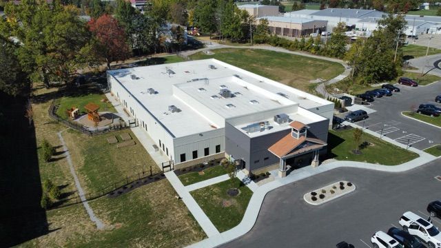 An aerial view of a large building with a parking lot in front of it.