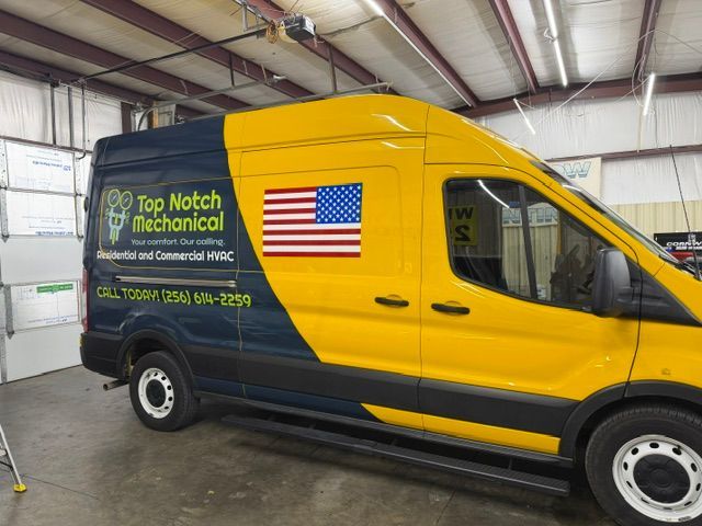Yellow and black service van with “Top Notch Technical” logo parked indoors.